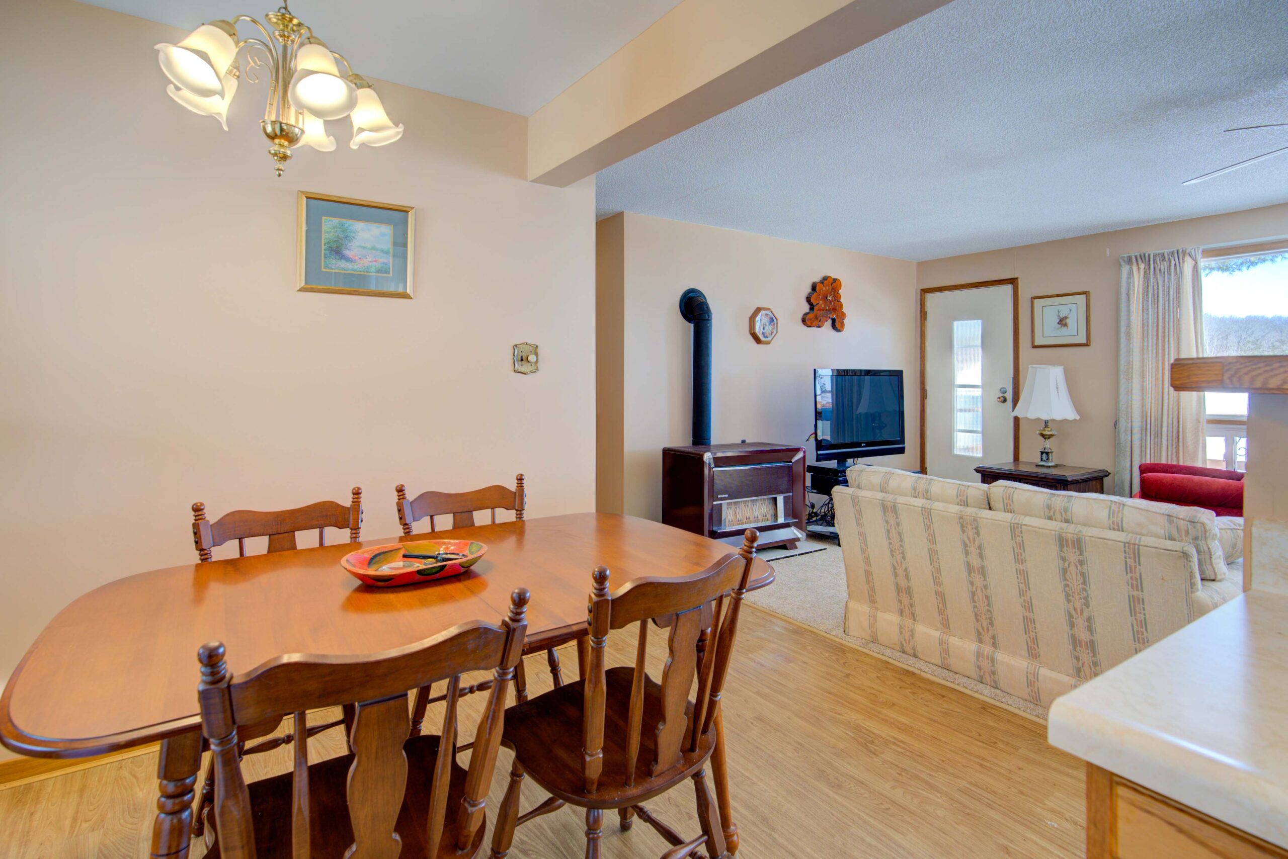 A wood dining table faces a spacious living room