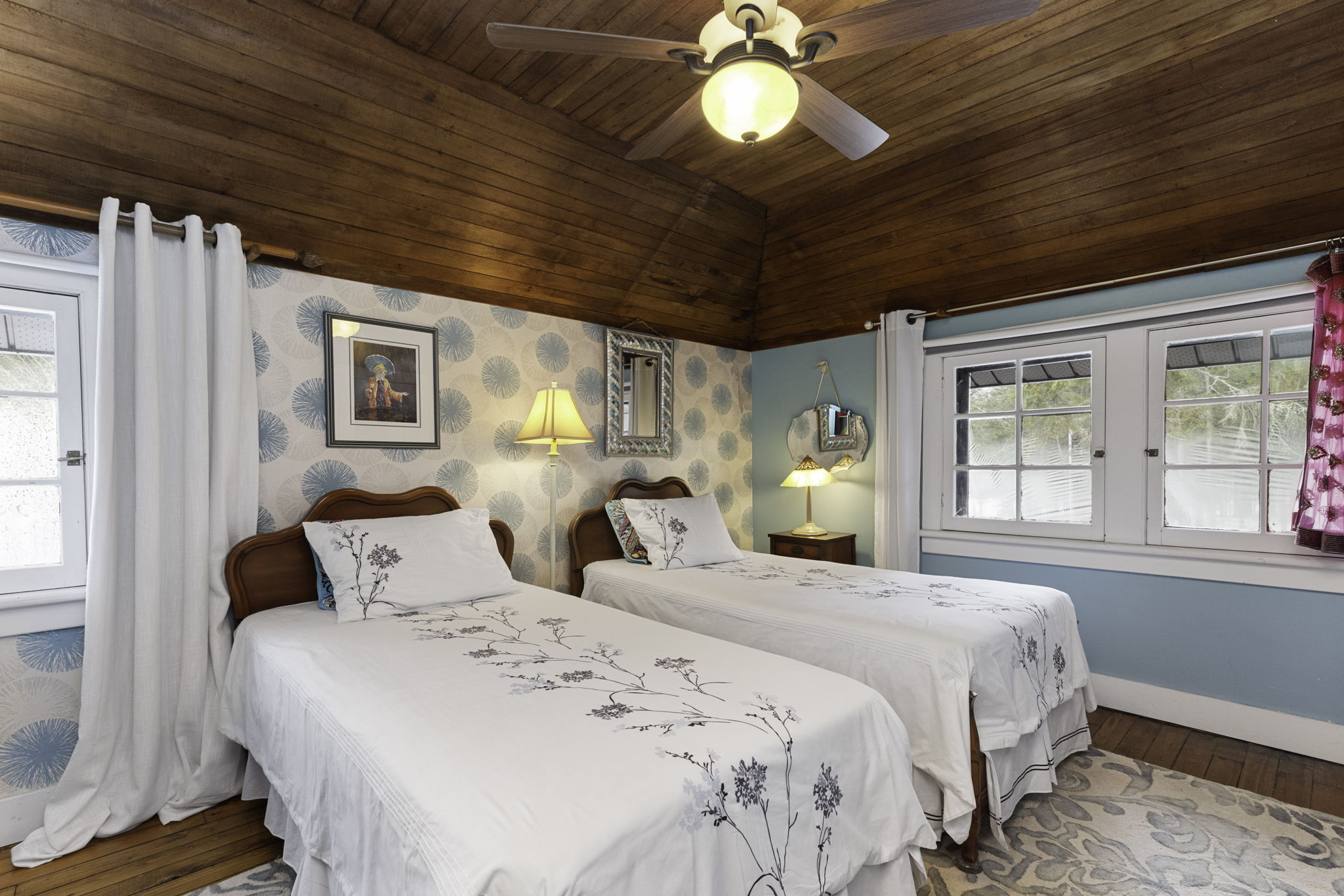 Spacious bedroom with wood ceilings and ample windows
