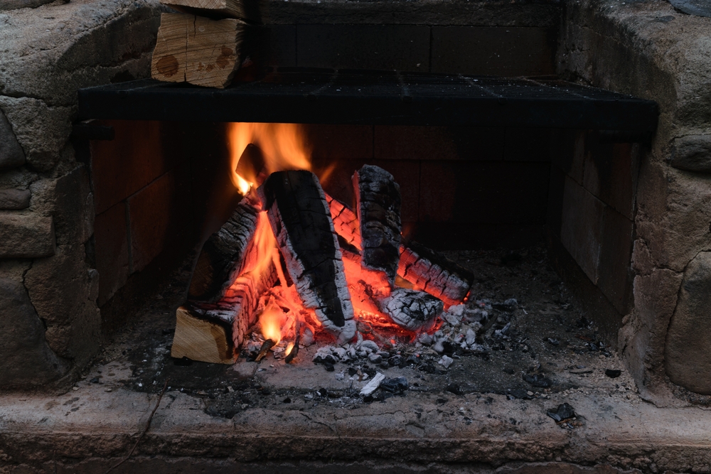 A cozy fireplace with a burning log in it