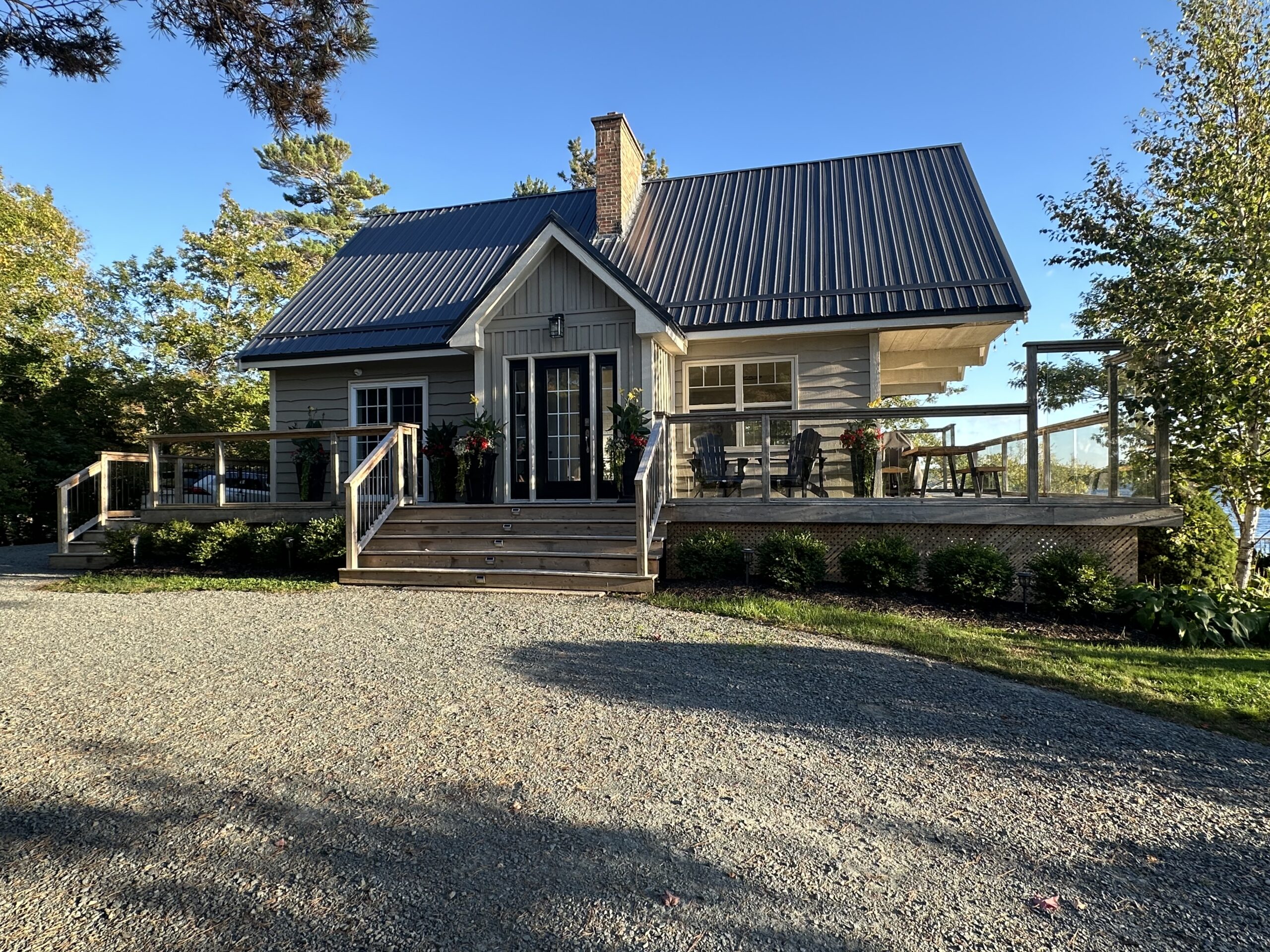A beige paneled cottage with steps leading to the front door