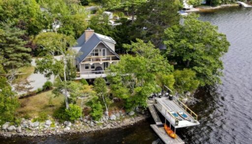 a multi-level cottage is set back into trees. The cottage overlooks a lake