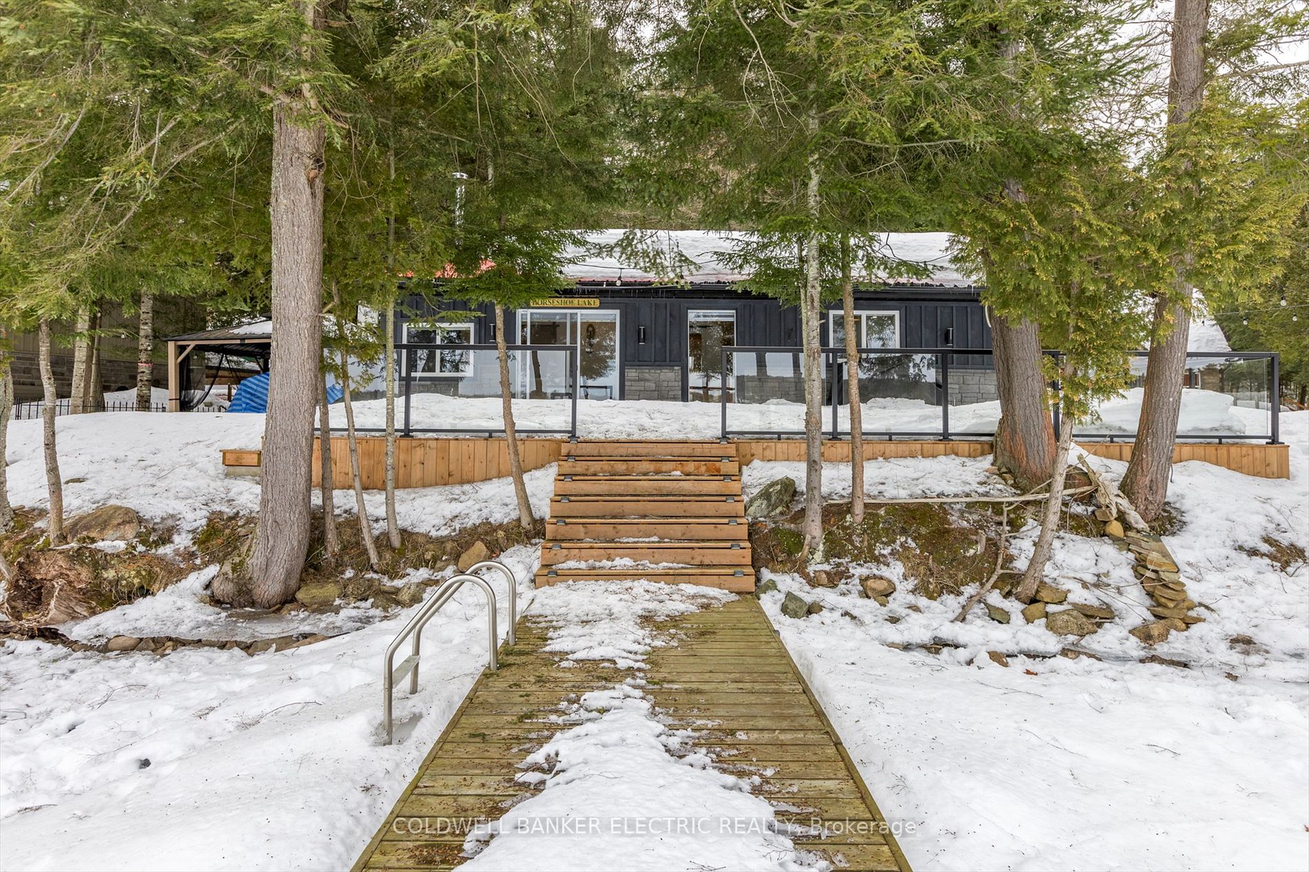 Winter view of the cottage with dock leading to Horseshoe Lake