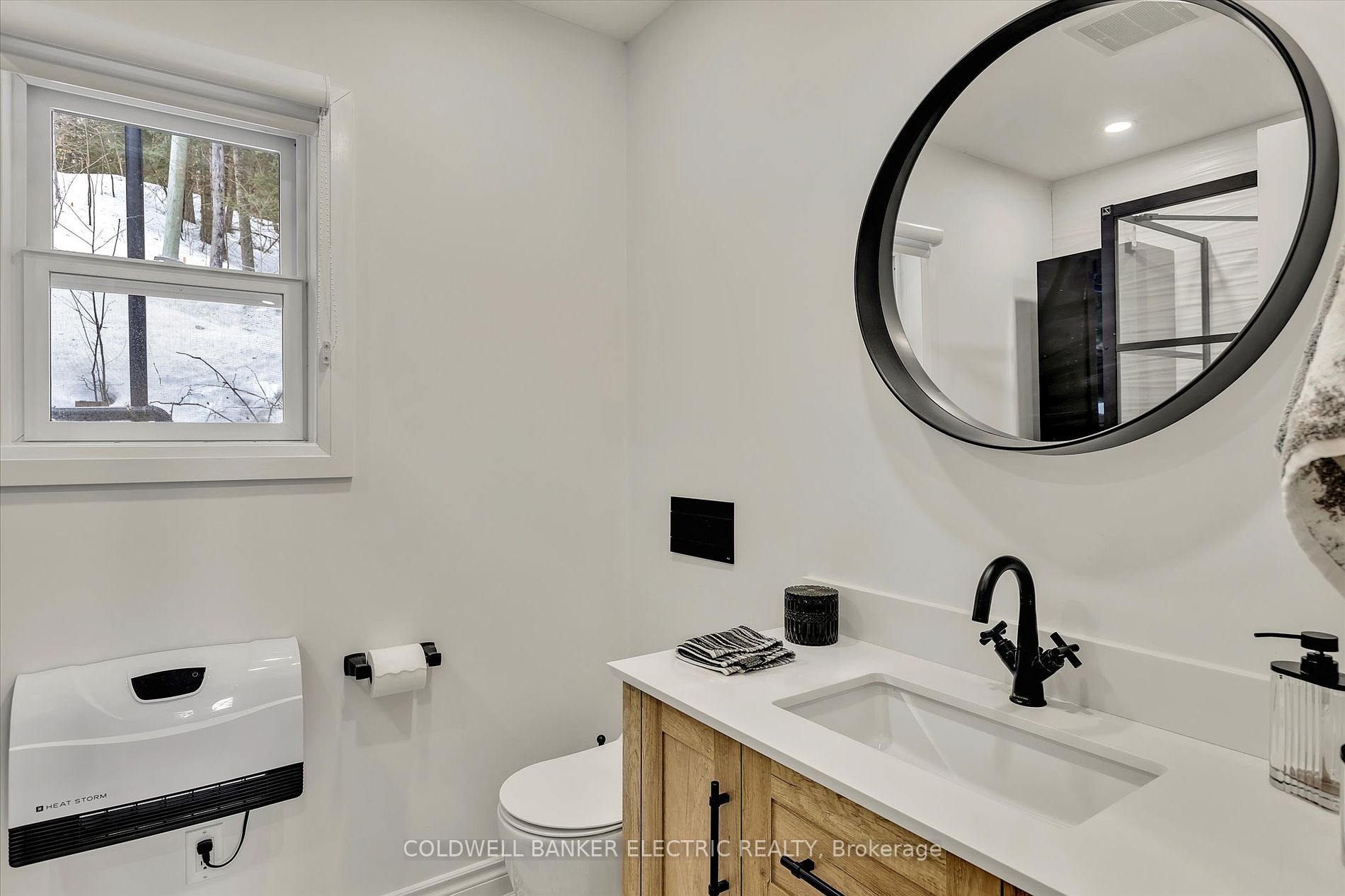Sleek bathroom with round mirror and floating vanity