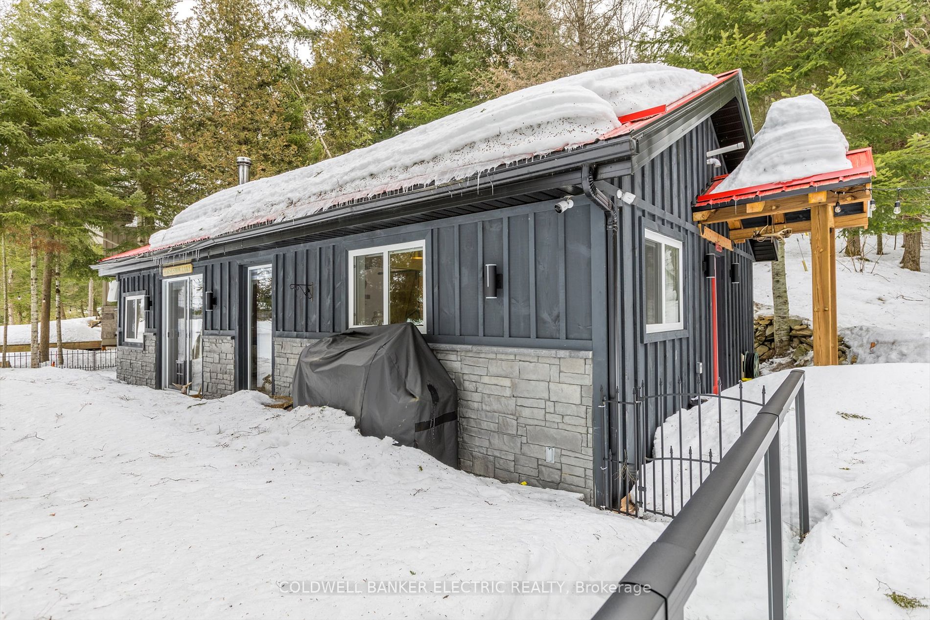 Wood stairs lead down to snowy yard and deck area