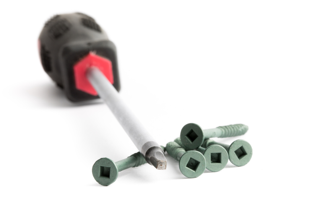 a close up of a square drive robertson style screwdriver and square drive socket wood screws that go together isolated on white