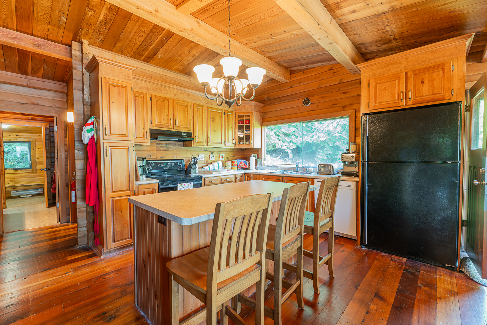 A wood kitchen island with wood high-top chairs in a wood kitchen