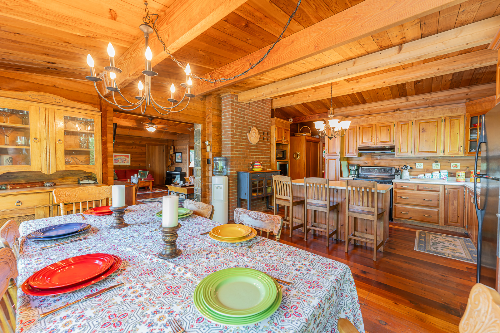 A patterned dining table faces a wood-paneled kitchen