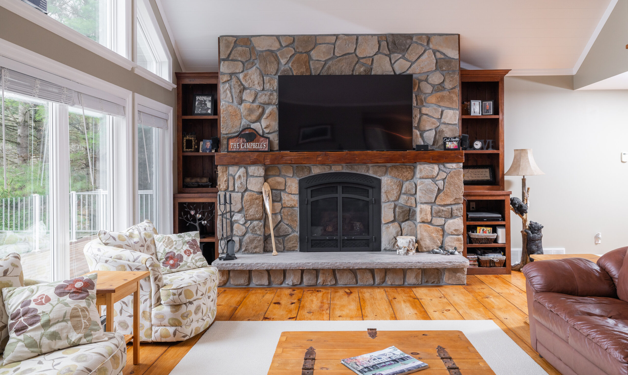 Propane fireplace with bricks, a wood mantle, and mounted television.