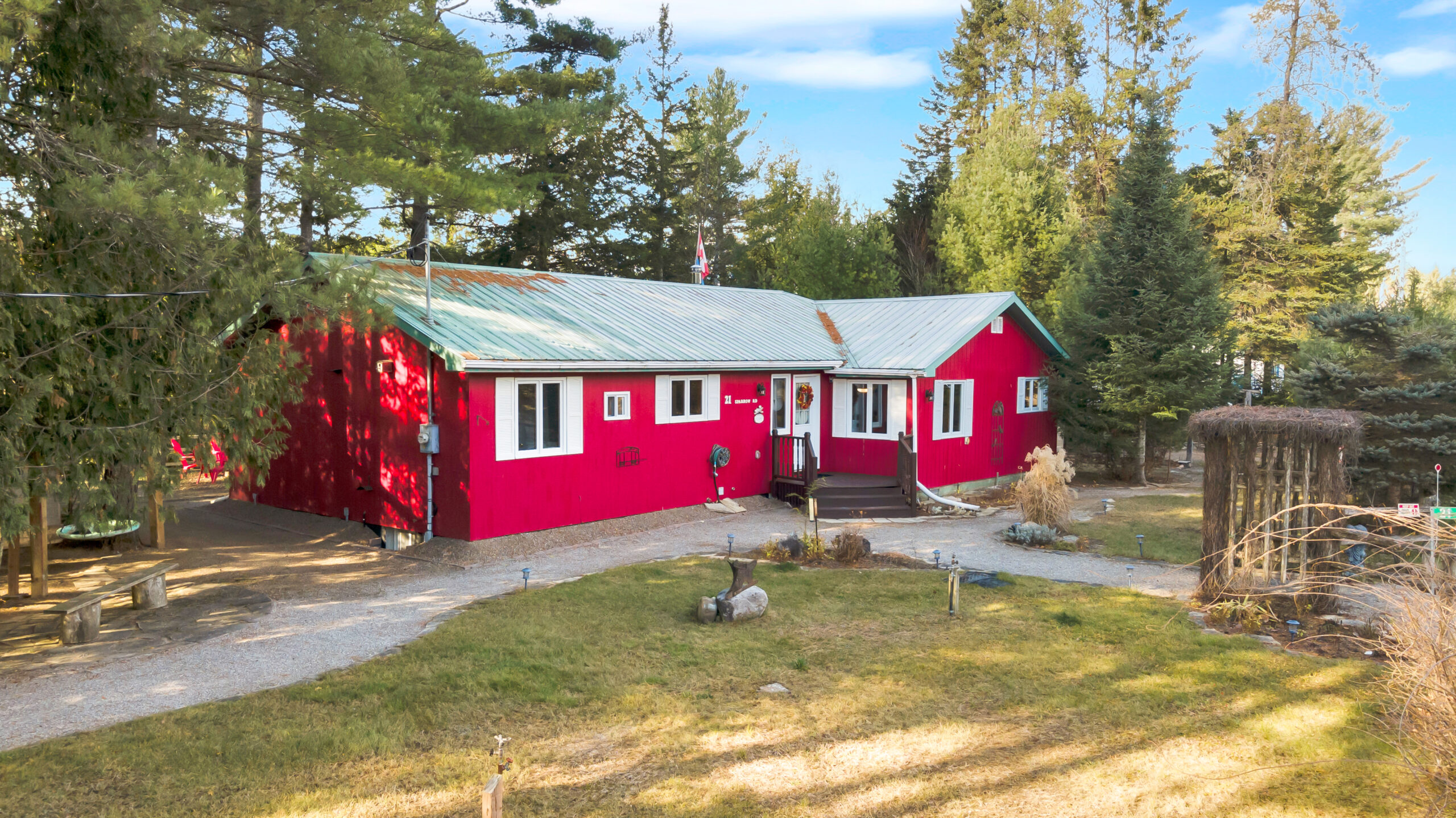 A red cottage with a grassy lawn in front