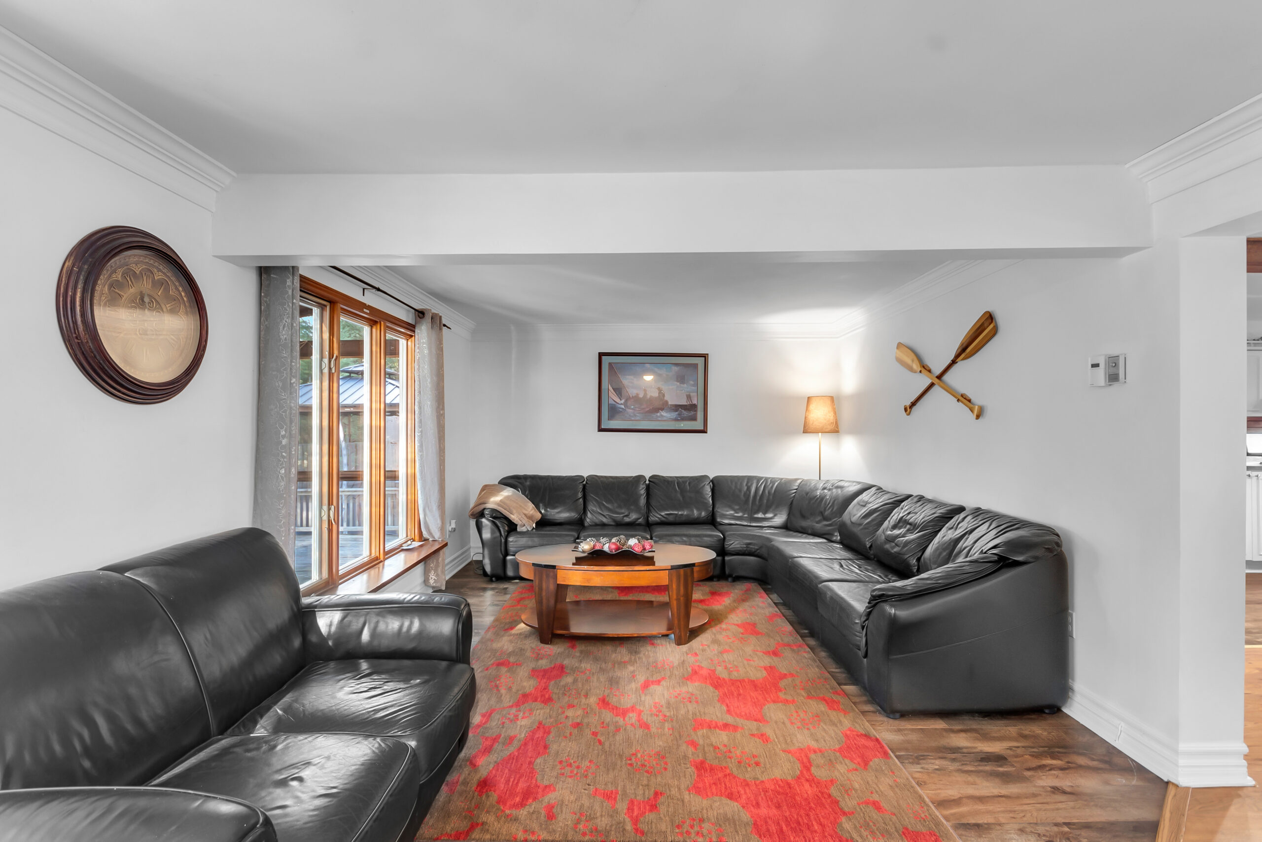 Black leather couches face each other in a white living room