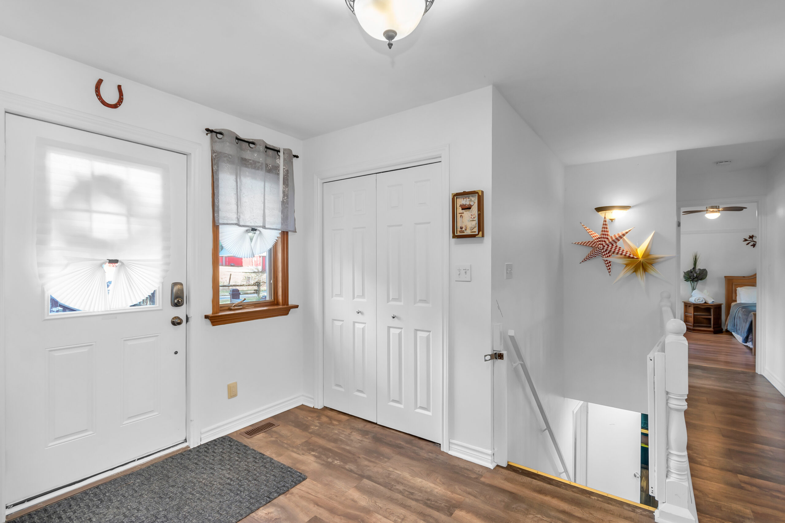 A white entryway with a small grey welcome mat