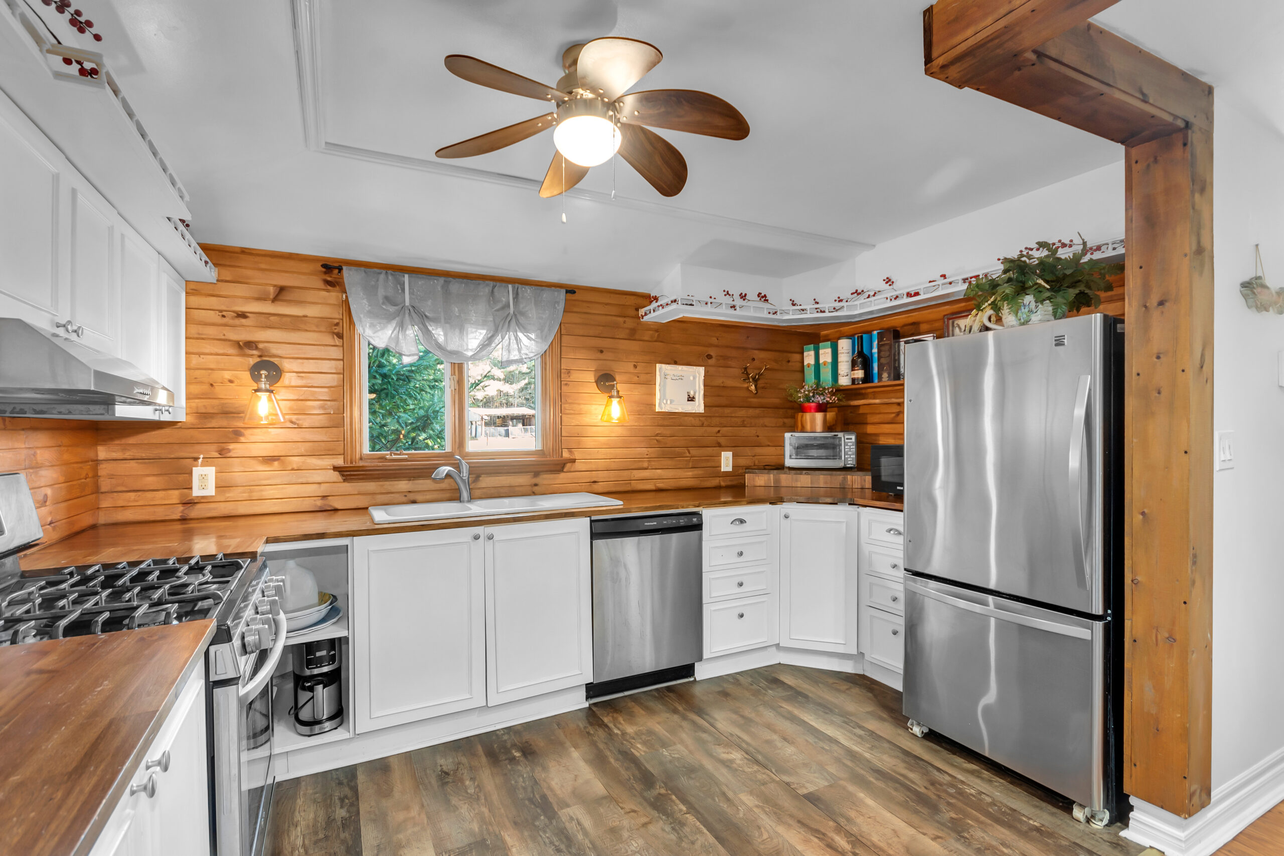 A white kitchen with a wood backsplash