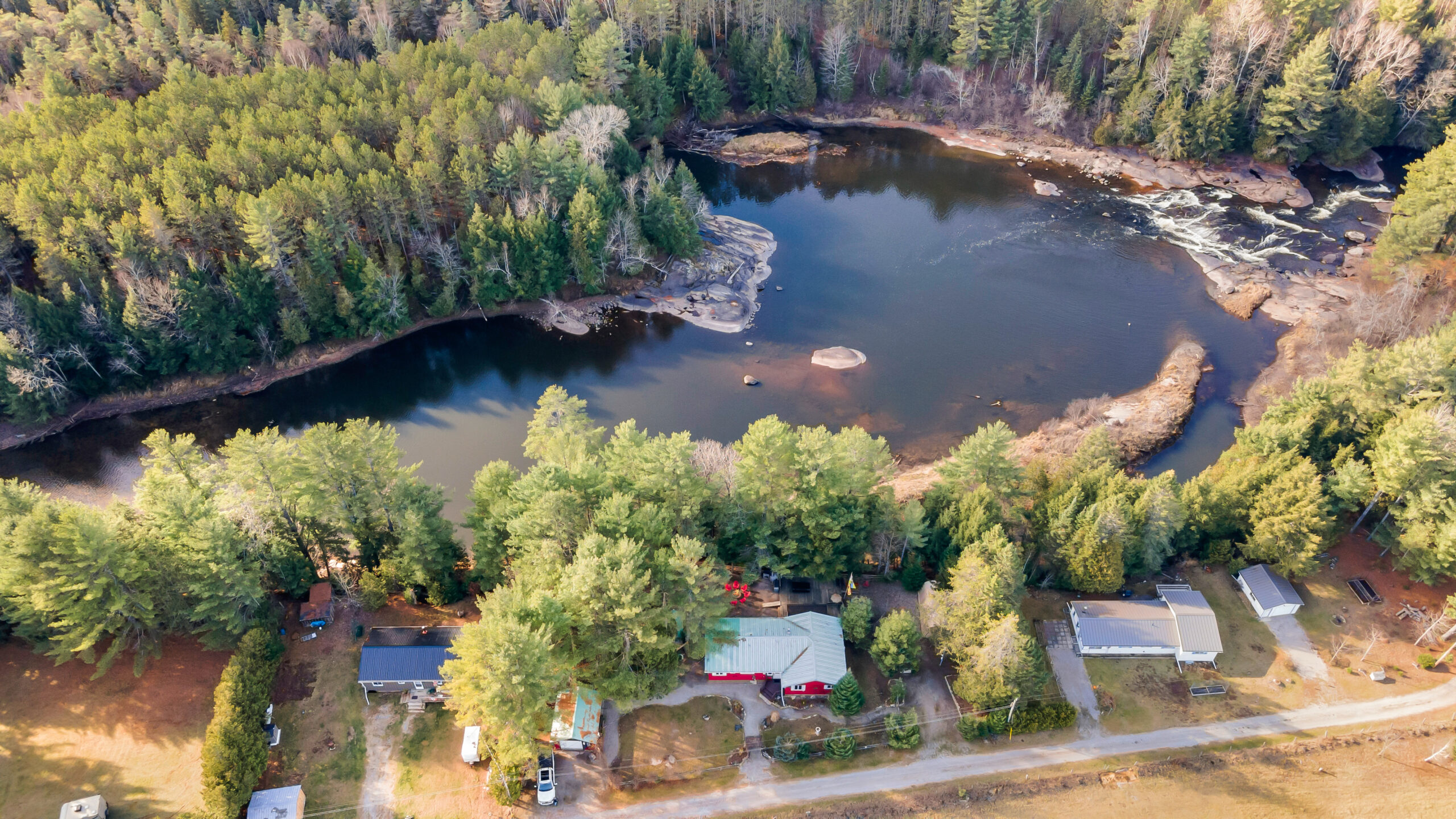 Aerial view of the red cottage in a forested area