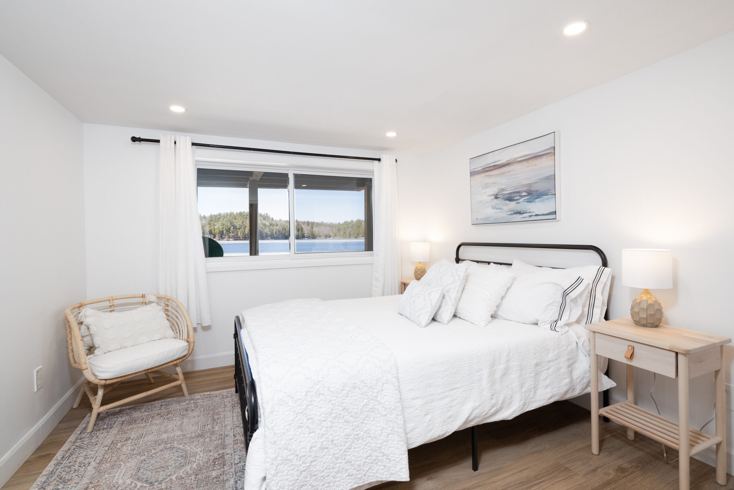 A white bed on a black metal bed frame