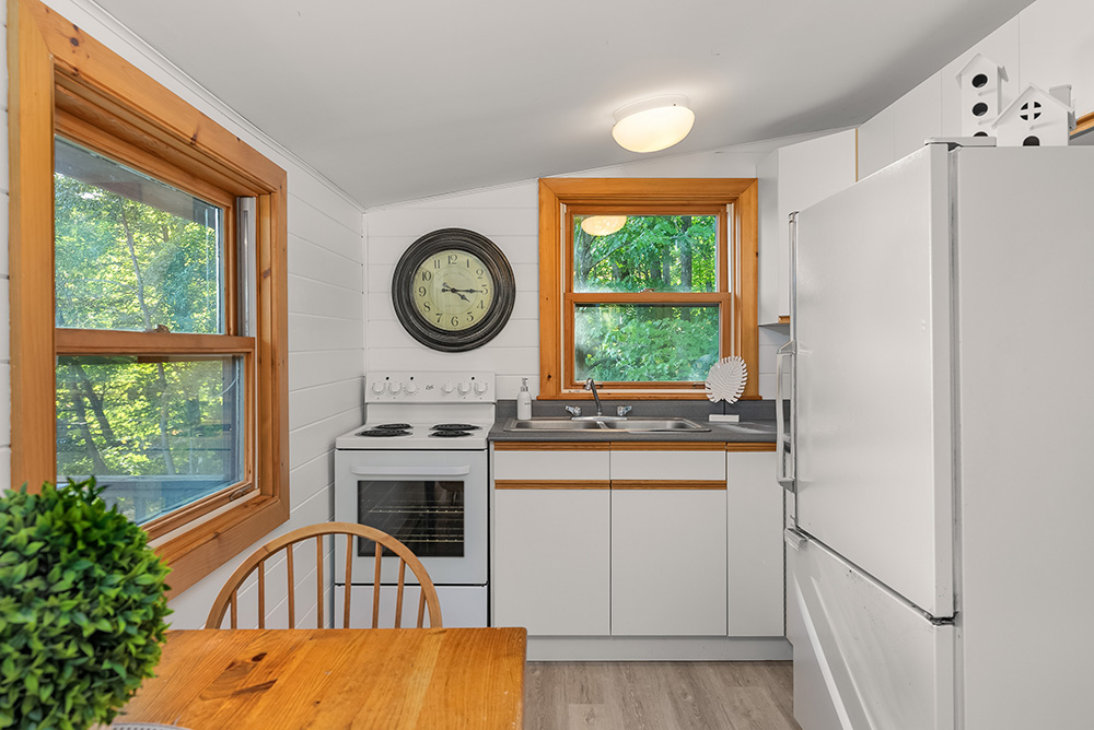 Compact kitchen in the guest cottage with full appliances and window views