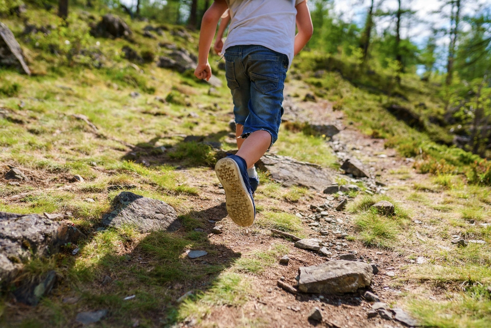 child running on the trail, taking kids to rural areas to help prevent allergies