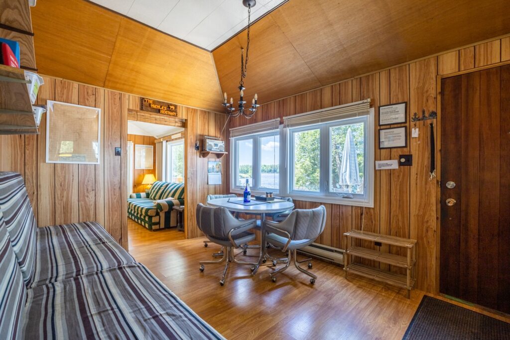 Interior of the Bear Lake Retreat featuring a bright, open-concept living space with large windows, a vaulted ceiling, and comfortable seating.