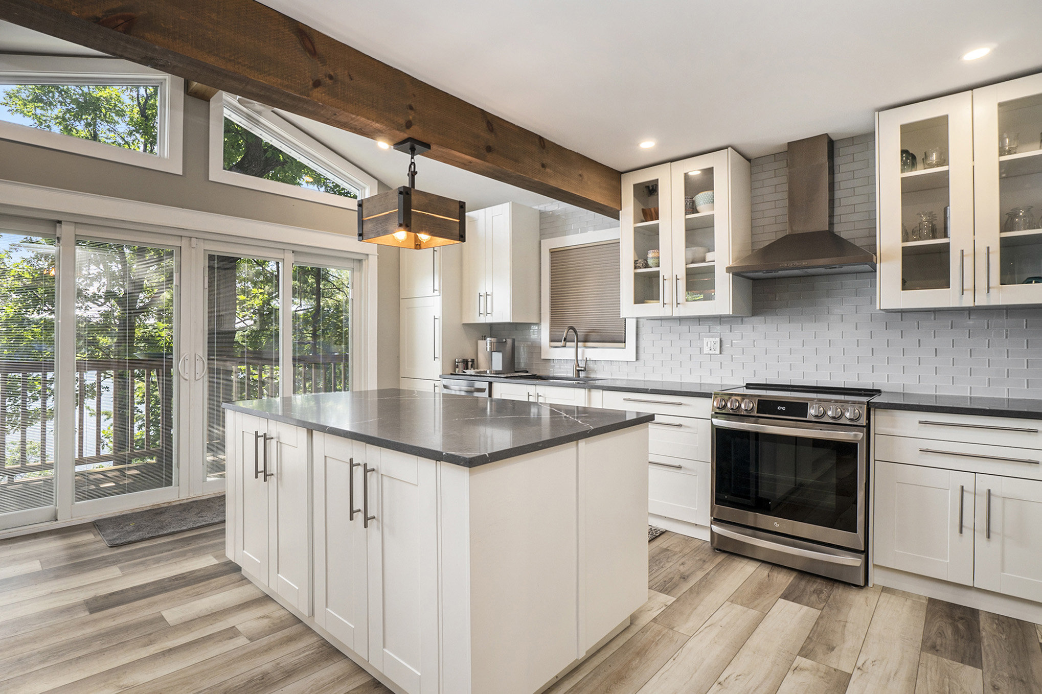 Stylish kitchen with white cabinetry, granite countertops, and stainless steel appliances