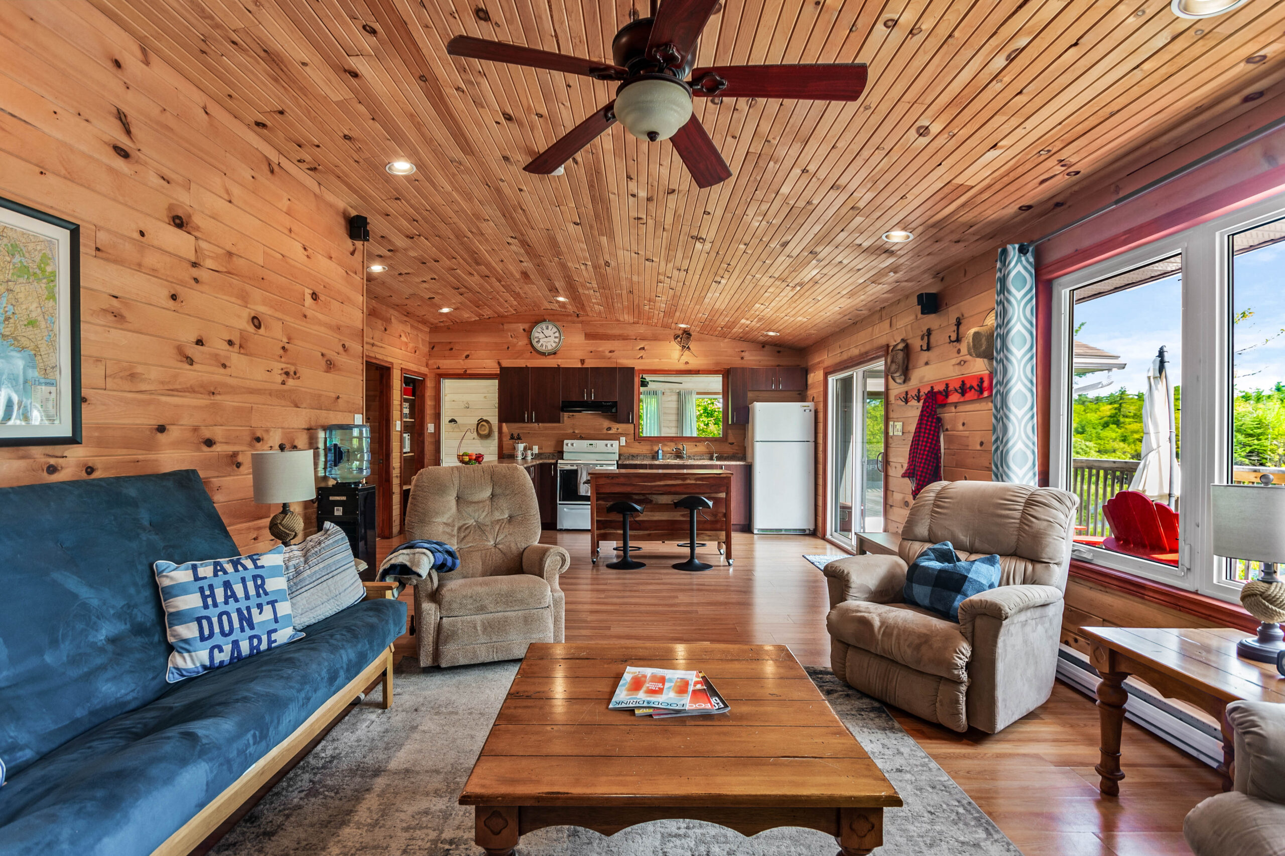 A wood coffee table surrounded with a wood-paneled kitchen behind