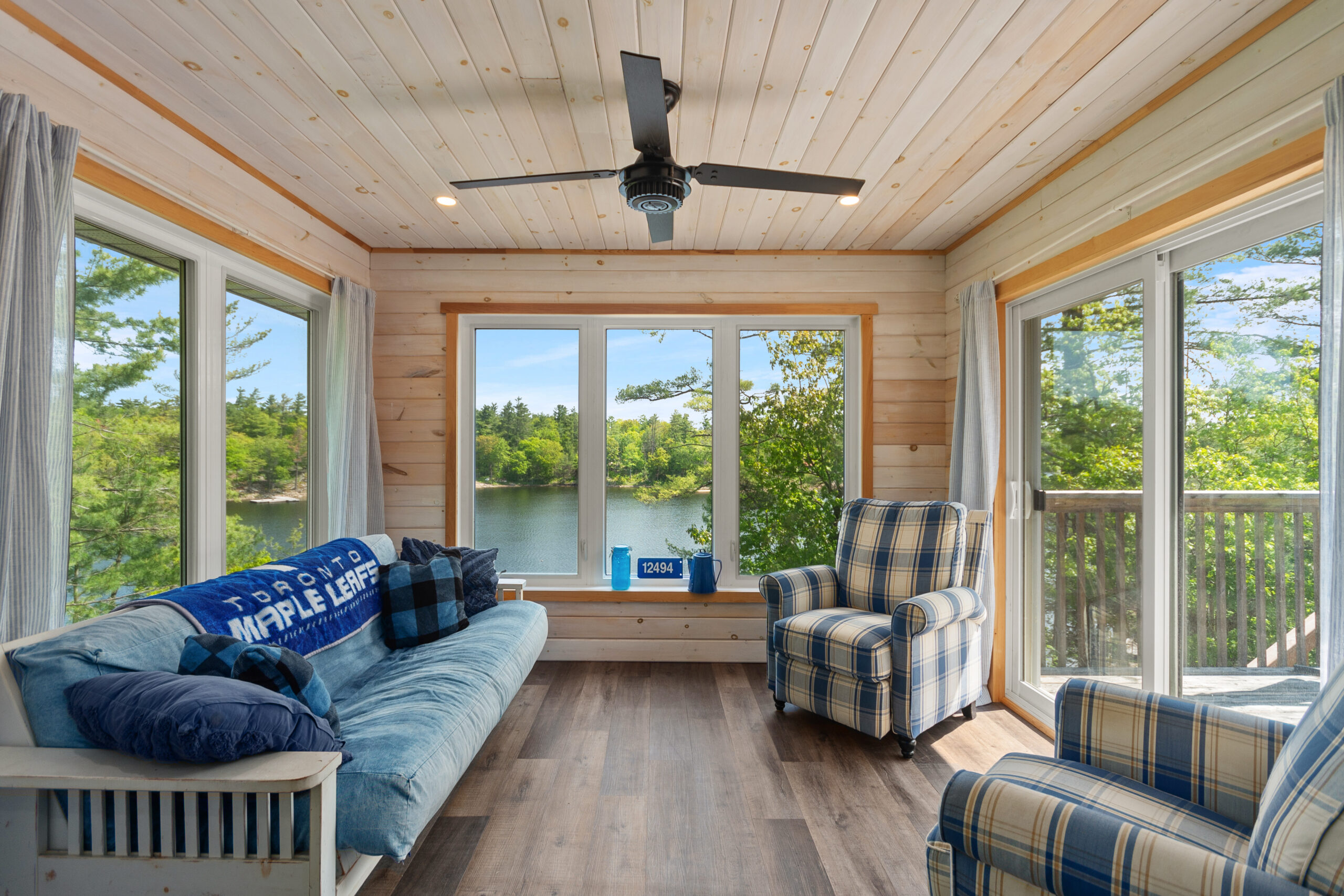 A blue couch facing blue-and-white chairs in a bright sun room