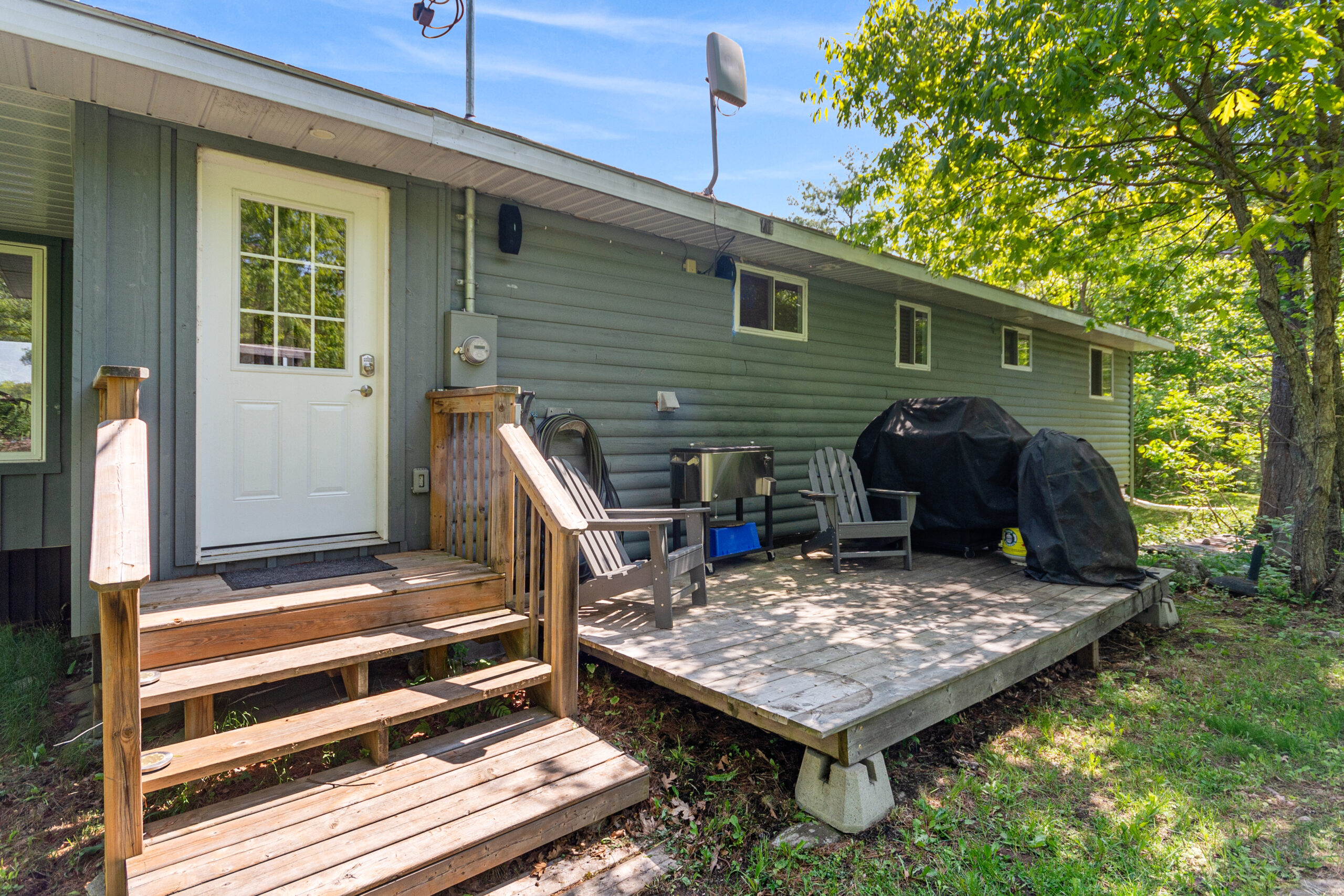 Wood steps leading up a grey cottage