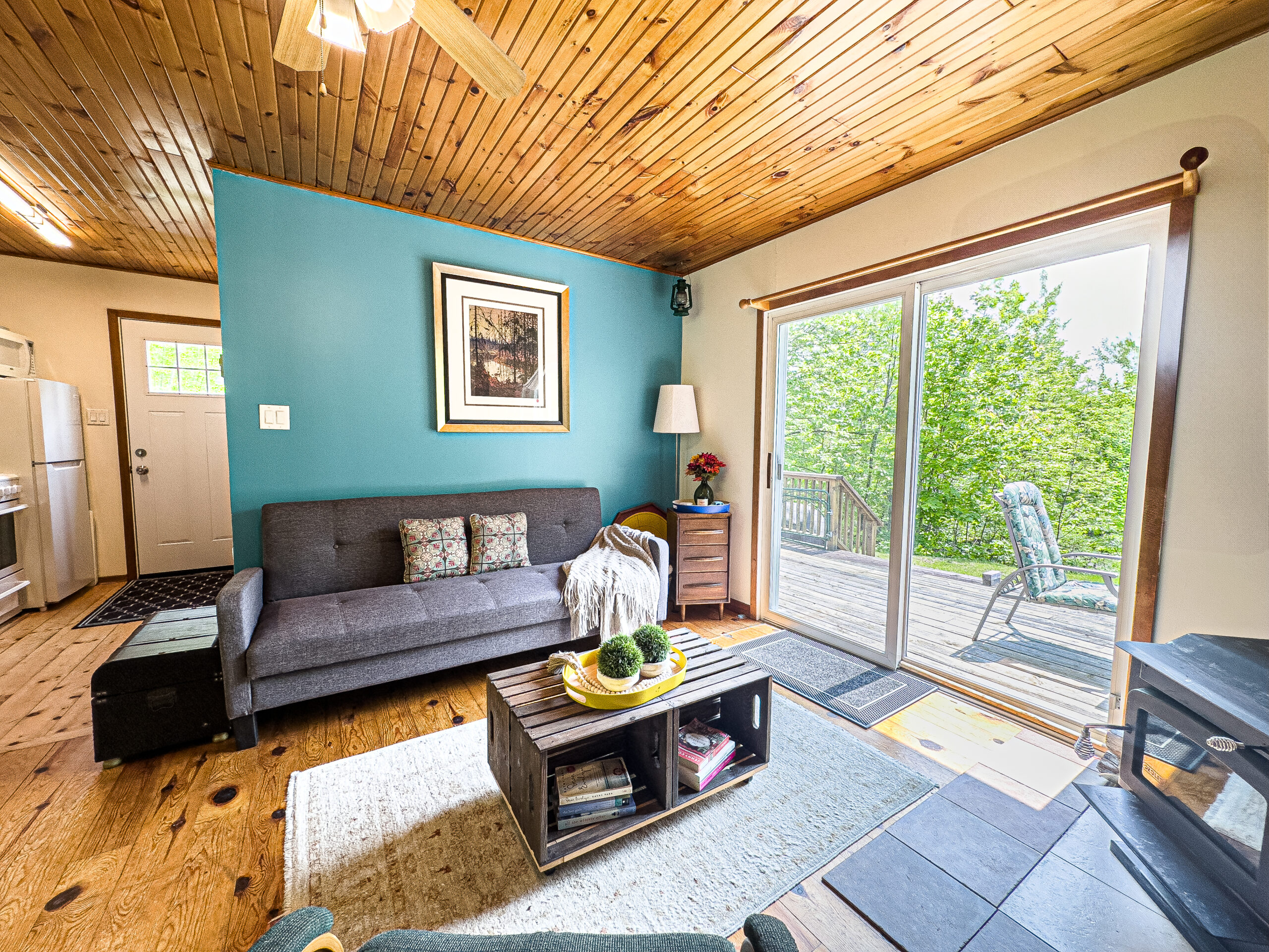A grey couch next to a bright blue wall faces a small wood table