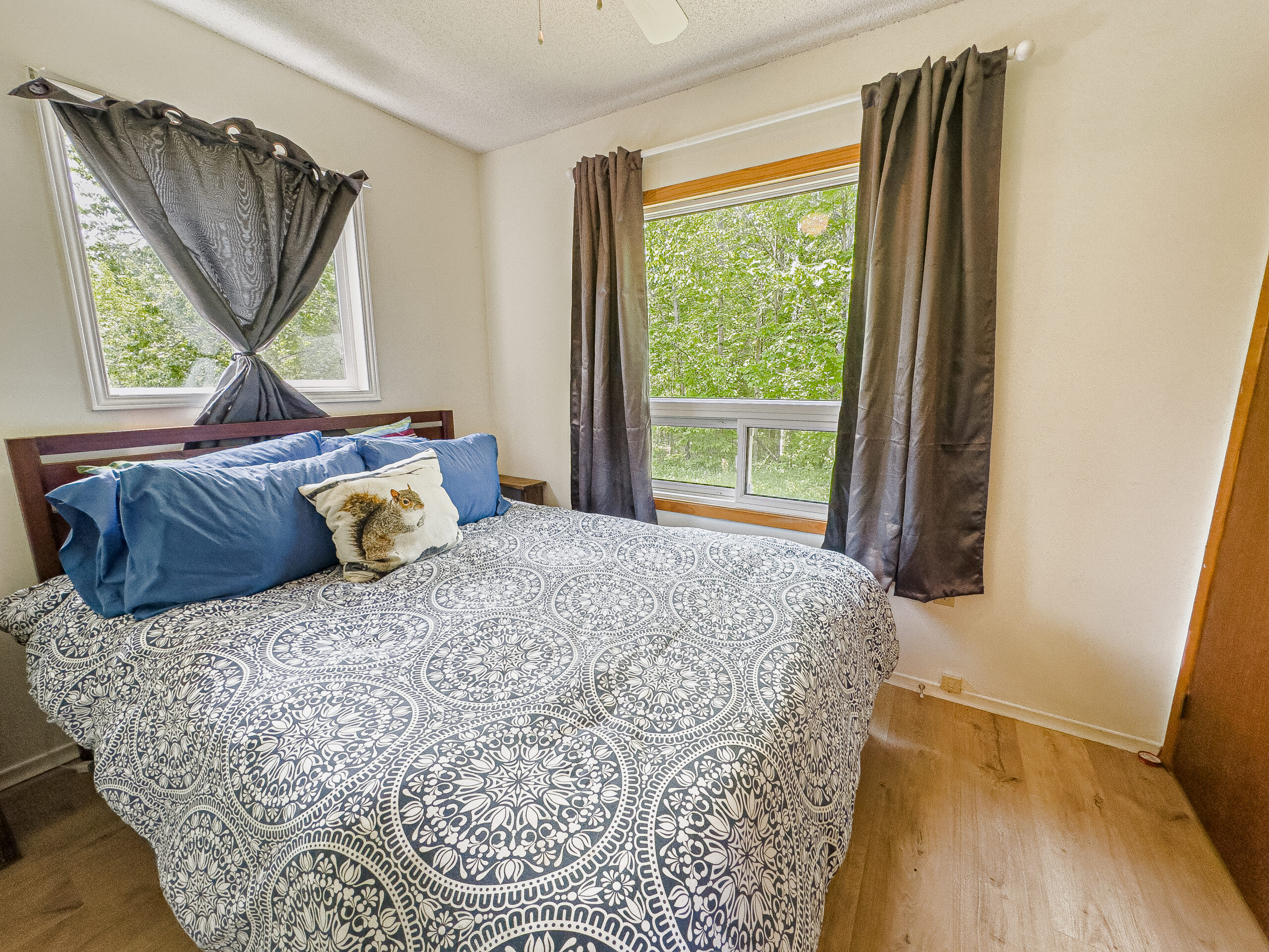 A bed with a grey-and-white duvet cover in a white bedroom