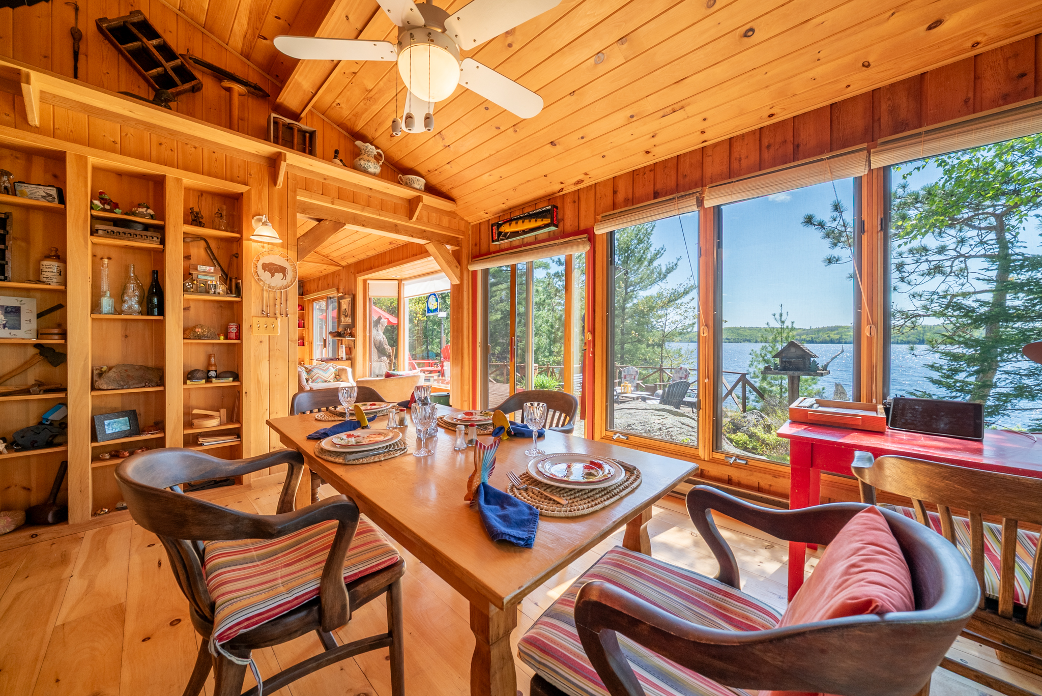 Open dining room with large windows overlooking the lake and surrounding trees
