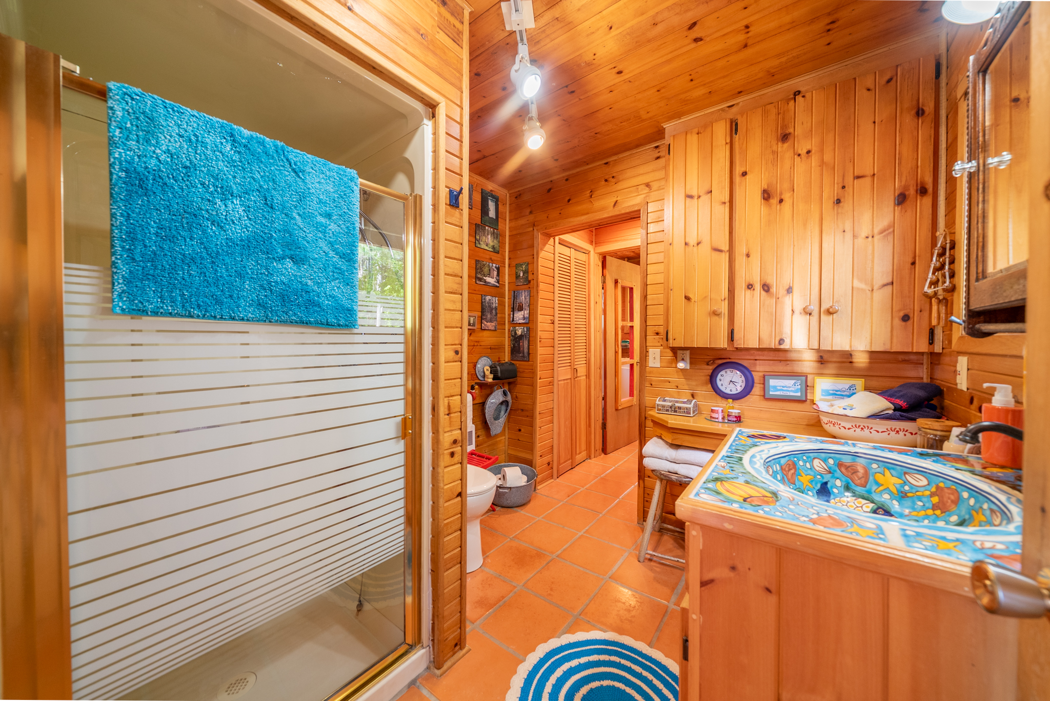 Unique bathroom featuring lake-themed artwork and wood cabinetry
