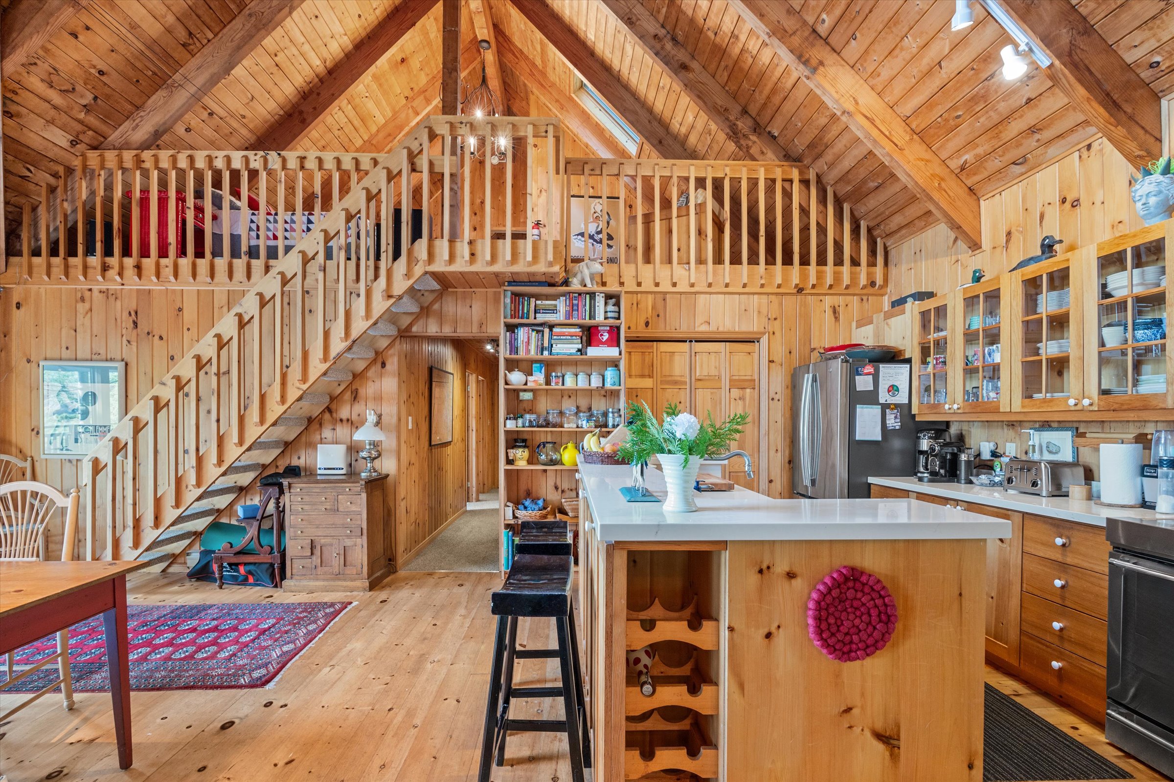 Spacious open-concept interior with dining area, kitchen island, and wood accents in the main cottage