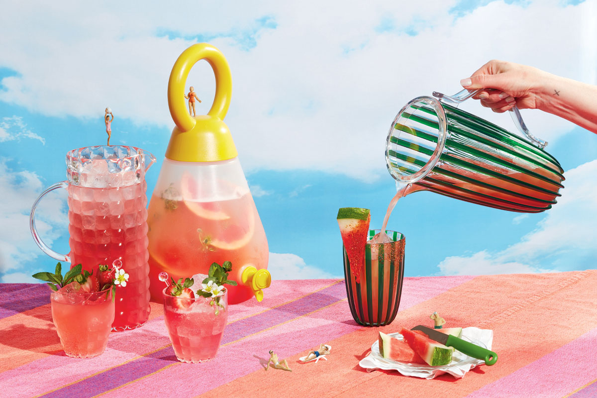 Pitchers of cocktails set against a blue sky background.