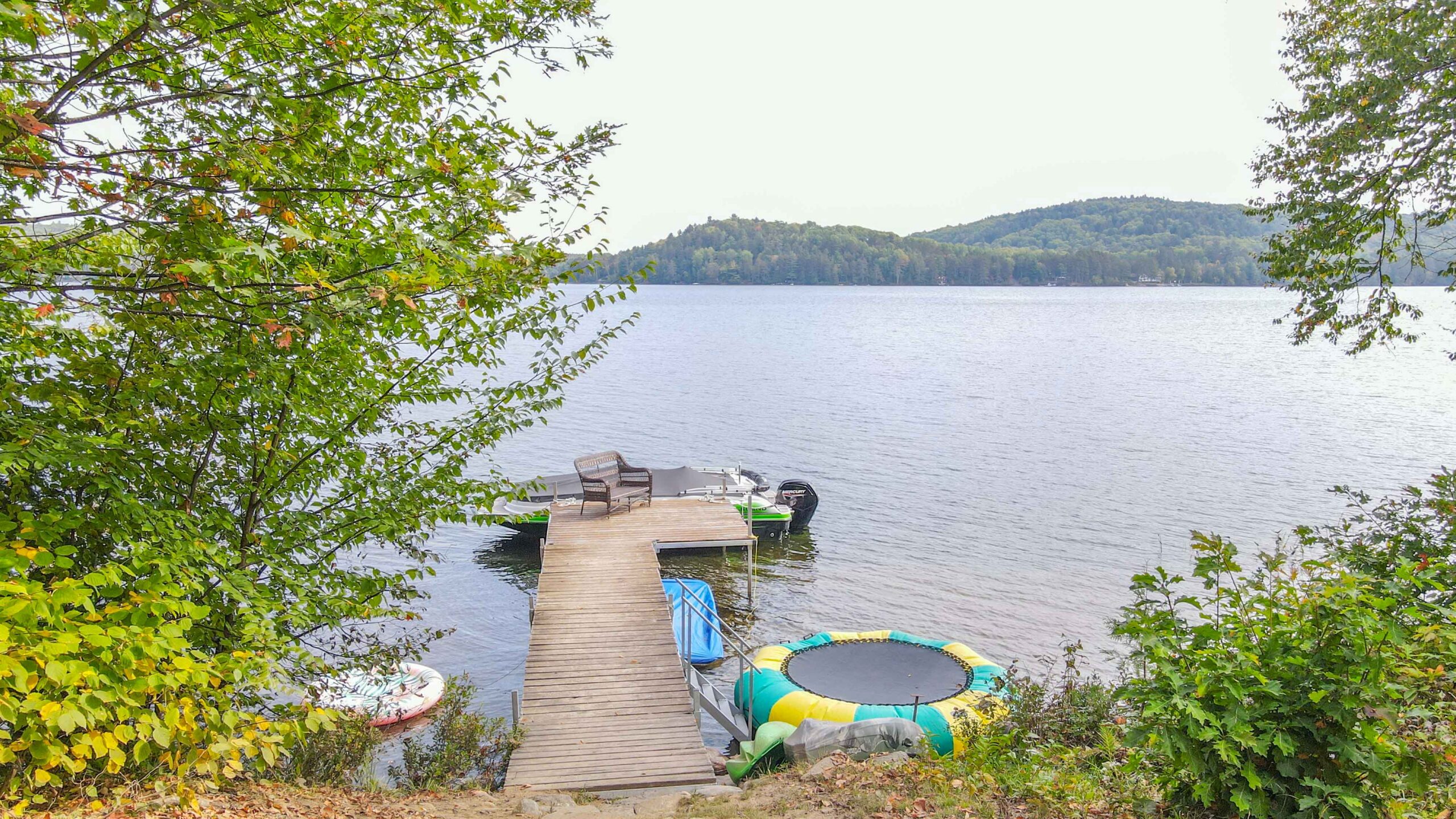 Cottage dock with swim ladder and water trampoline, looking out over Trout Lake.