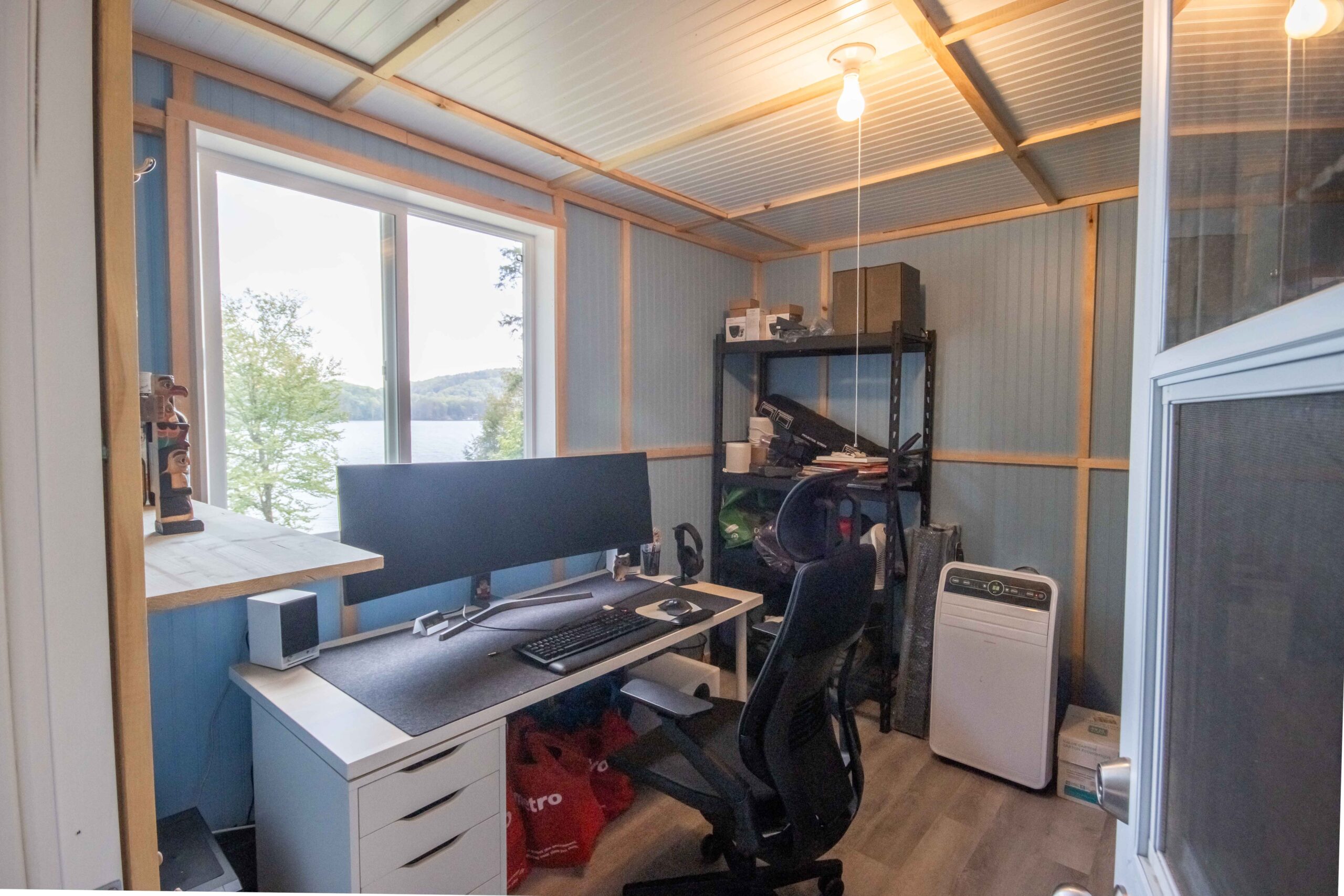Compact workspace with large desk, monitor, and outdoor views.