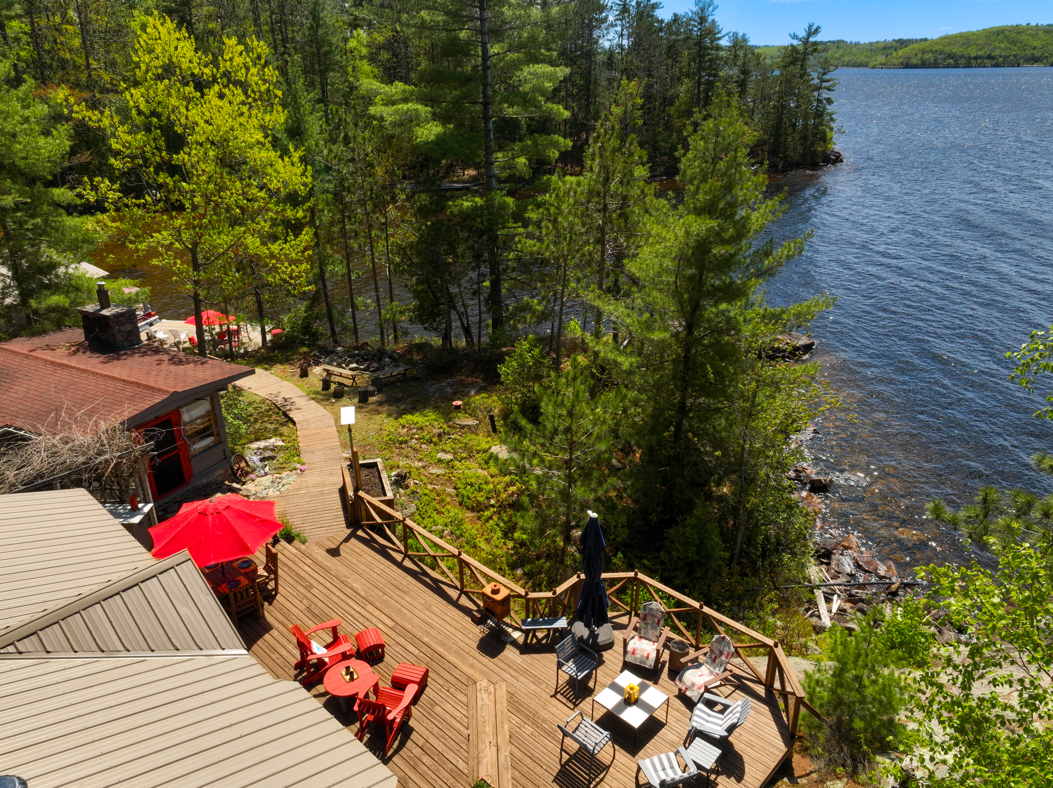 Overhead view of patio with outdoor seating nestled between forest and the lakefront