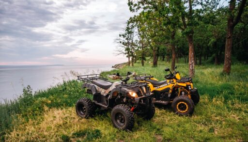 Two ATVs parked beside a lake
