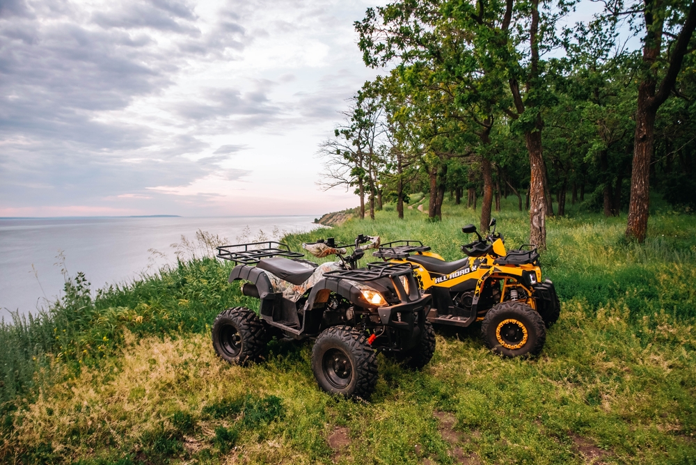 Two ATVs parked beside a lake