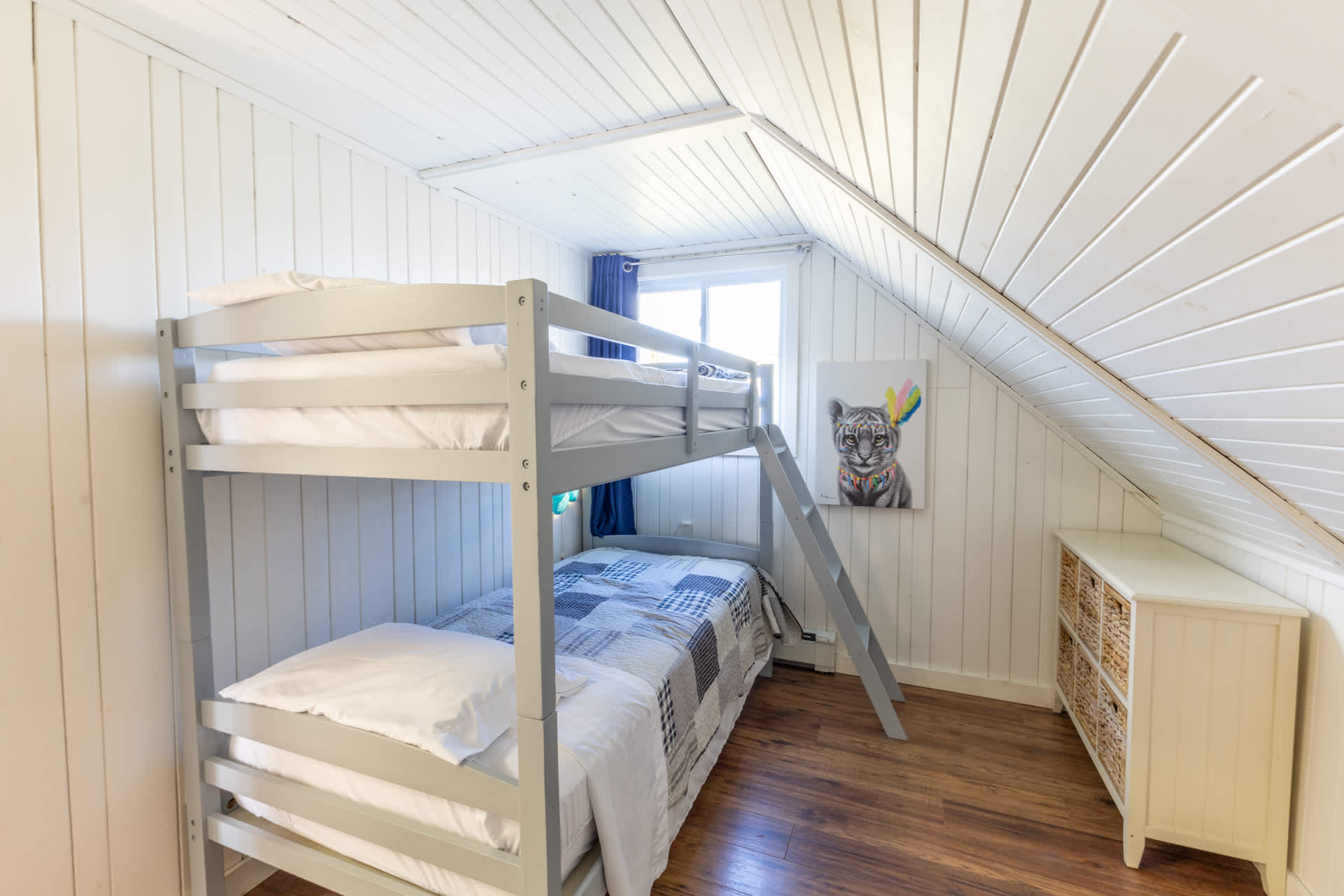 A white bunk bed with white covers in a white room