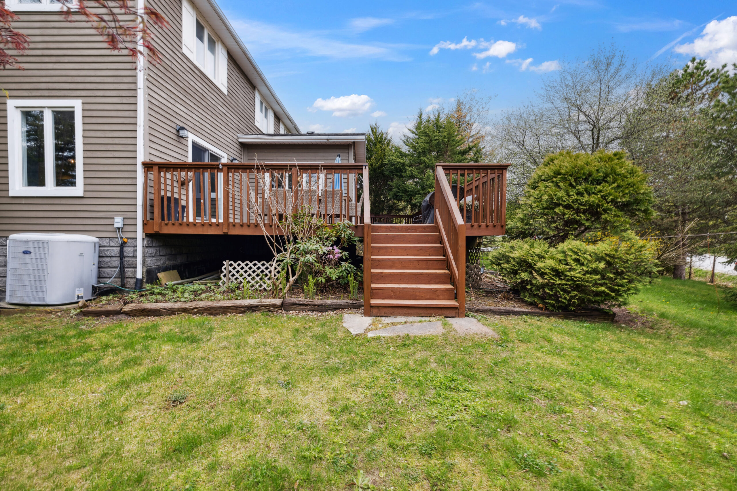 Steps on a wood deck lead down onto a grassy area