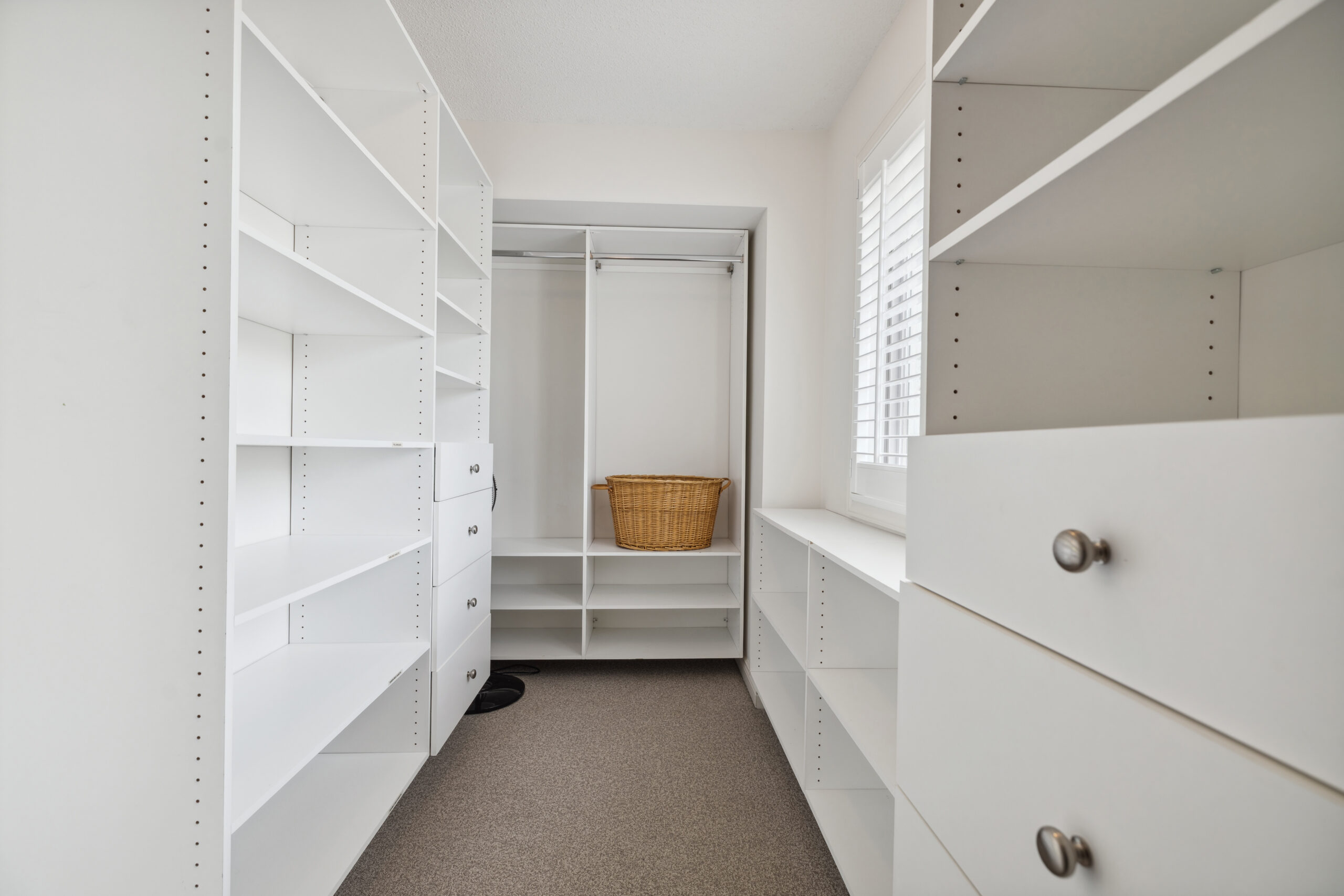 An empty white walk-in closet