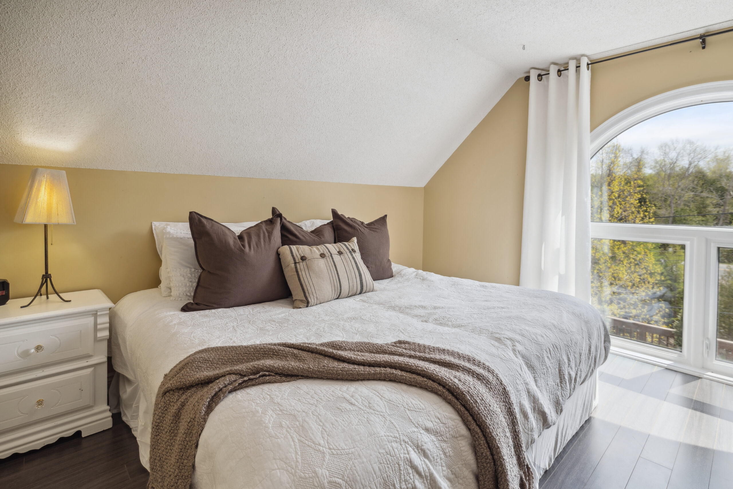 A bed with dark brown pillows