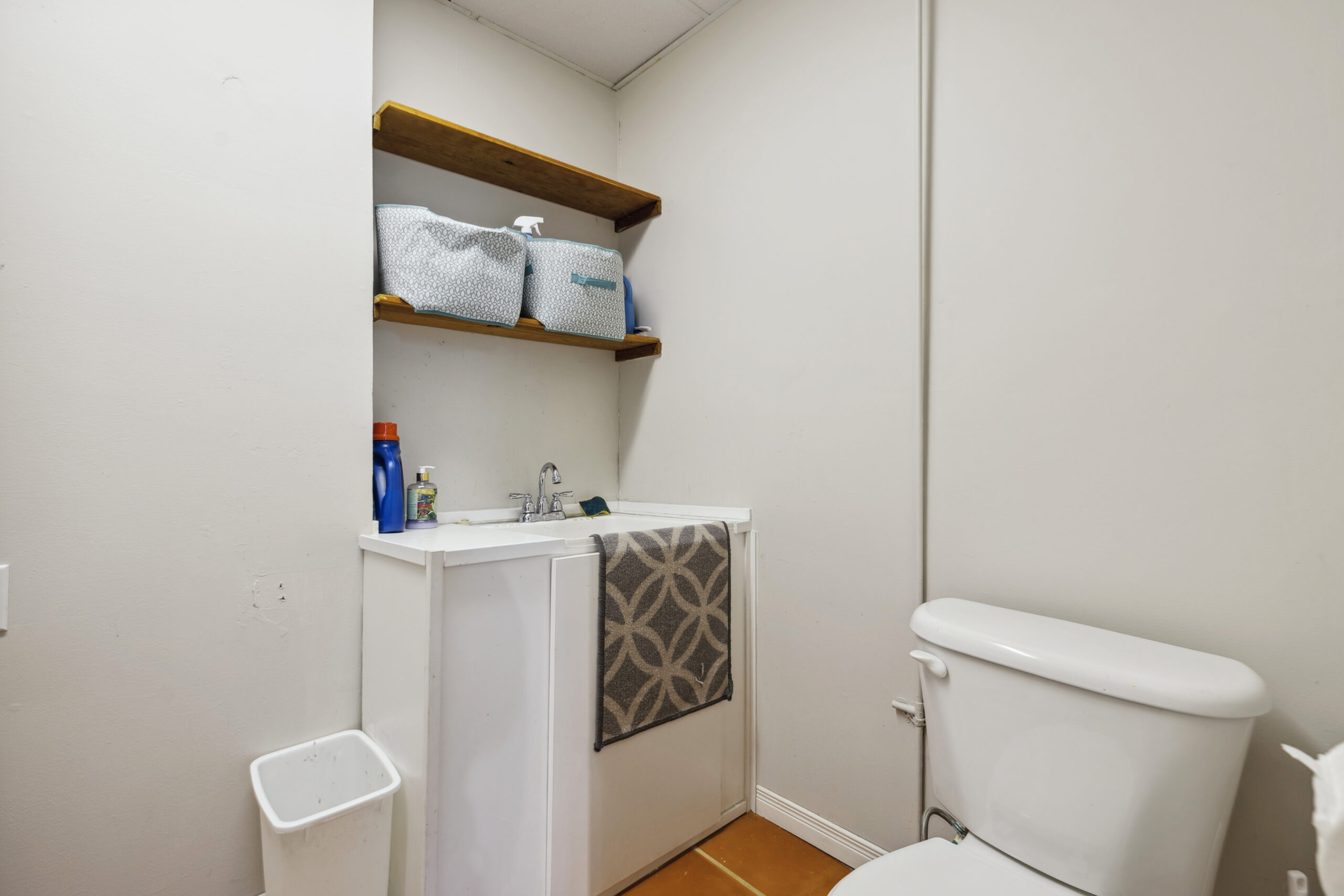 A toilet next to a white sink in a white room