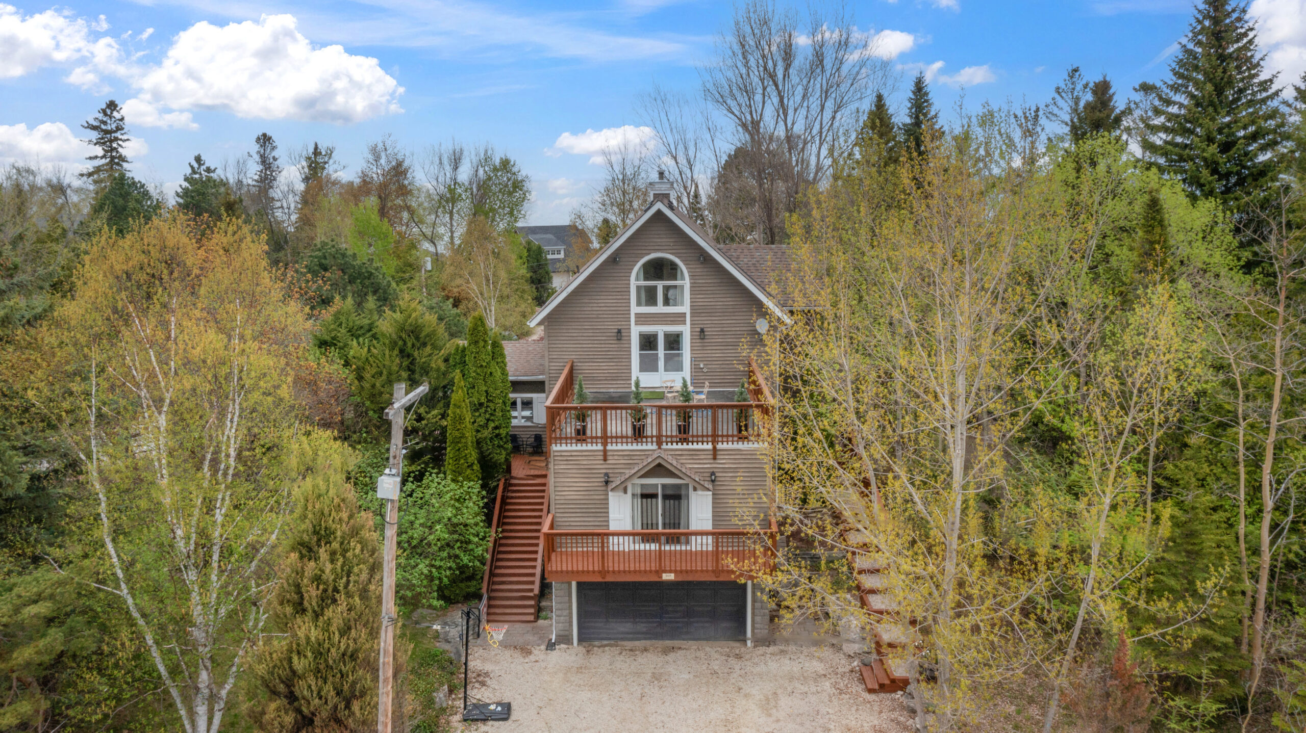 A brown wood-paneled cottage with two decks