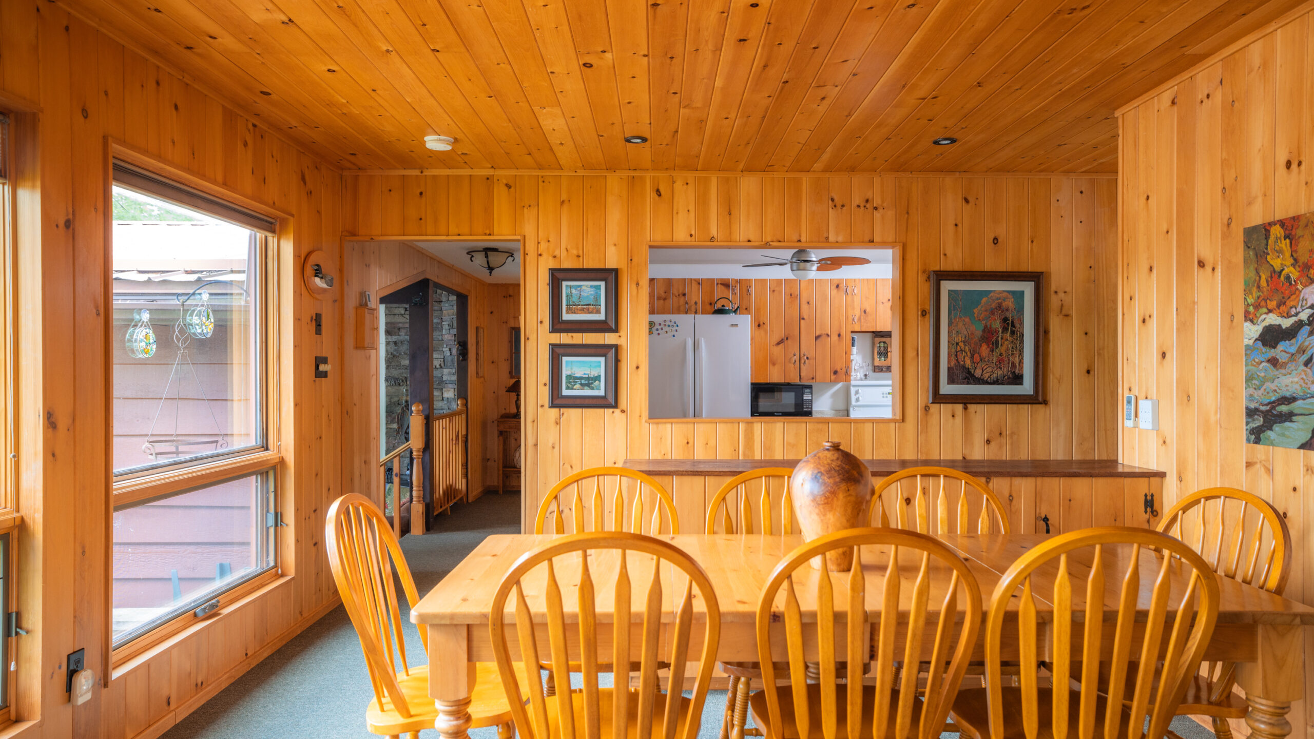 A wood paneled dining room with a wood dining set