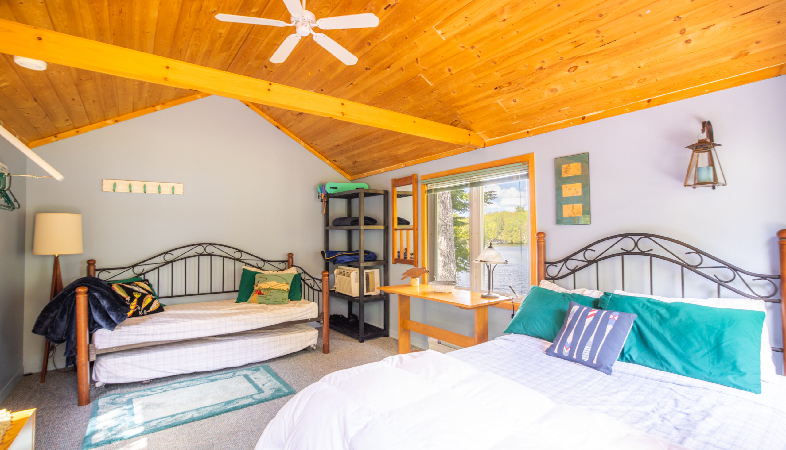 Two white beds in a white bedroom with slanted wood ceilings