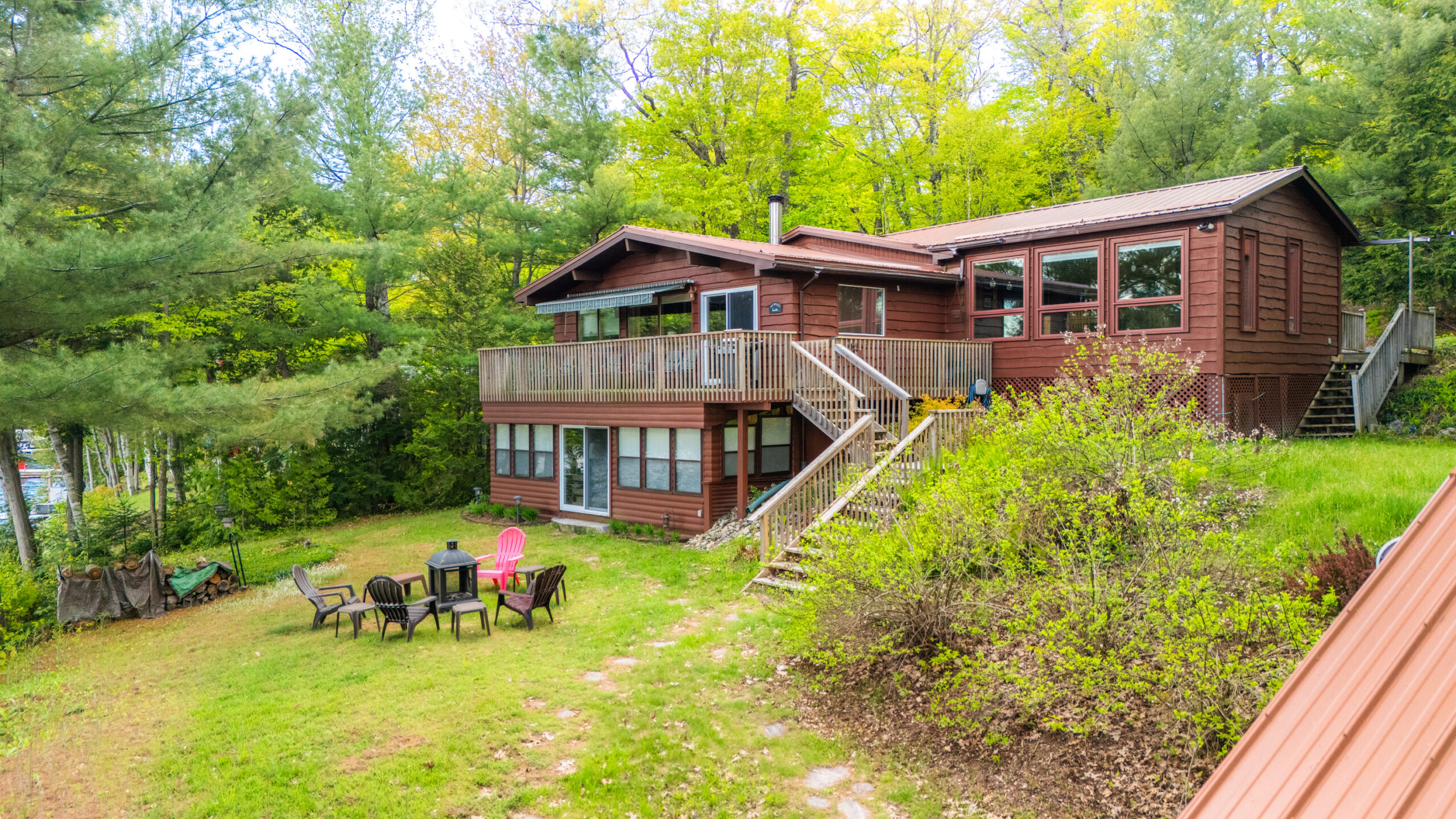 A two-level brown paneled cottage in the forest