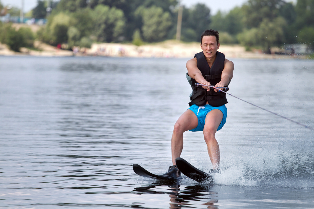 A man on waterskis being towed by a line