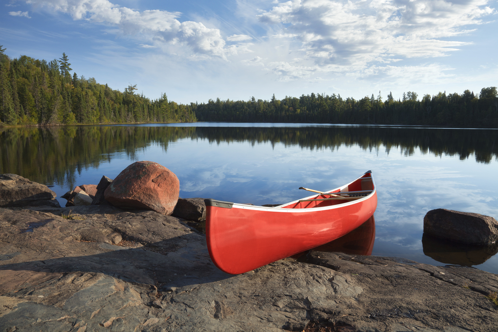A red canoe resting on the rocks