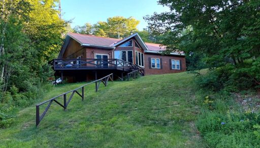 A wood cabin on a grassy lawn
