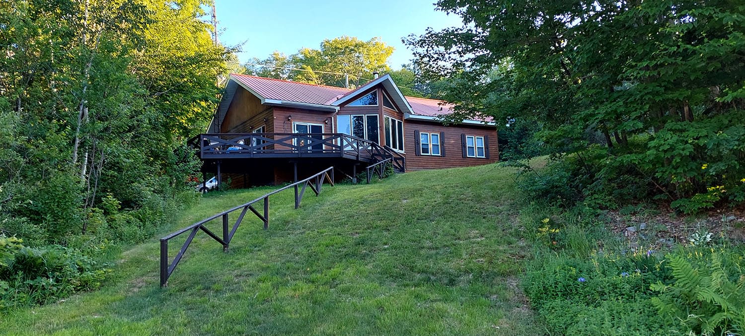 A wood cabin on a grassy lawn
