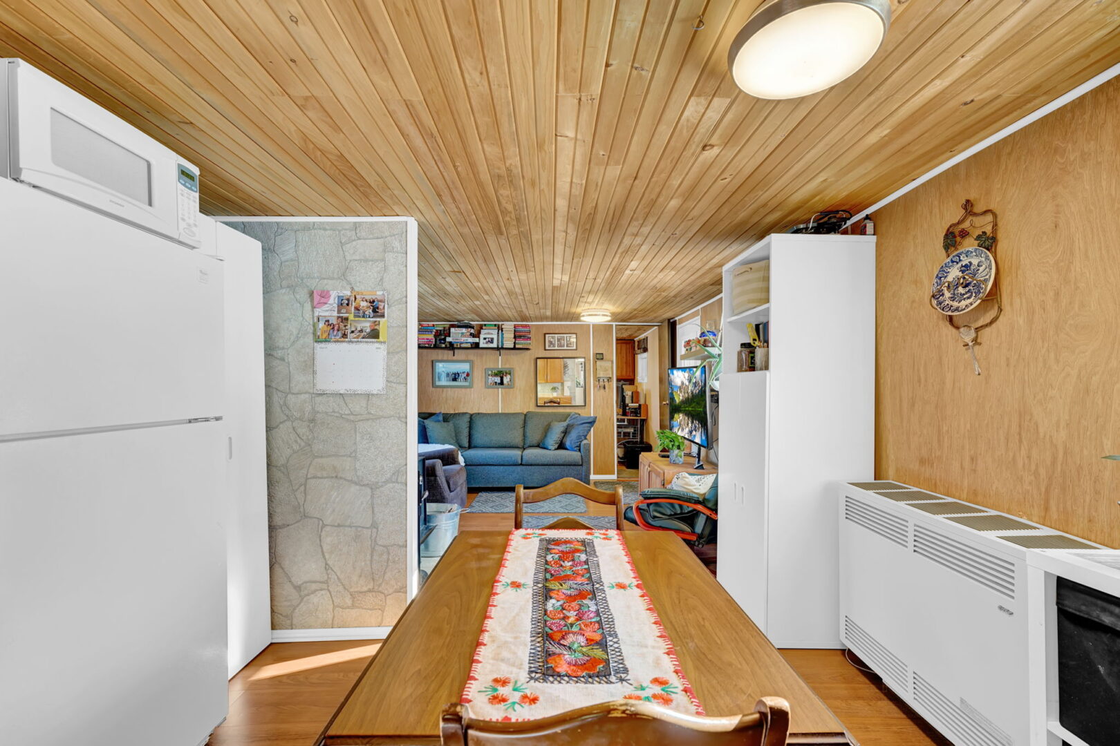 A wood table looks out at the wood-paneled living room